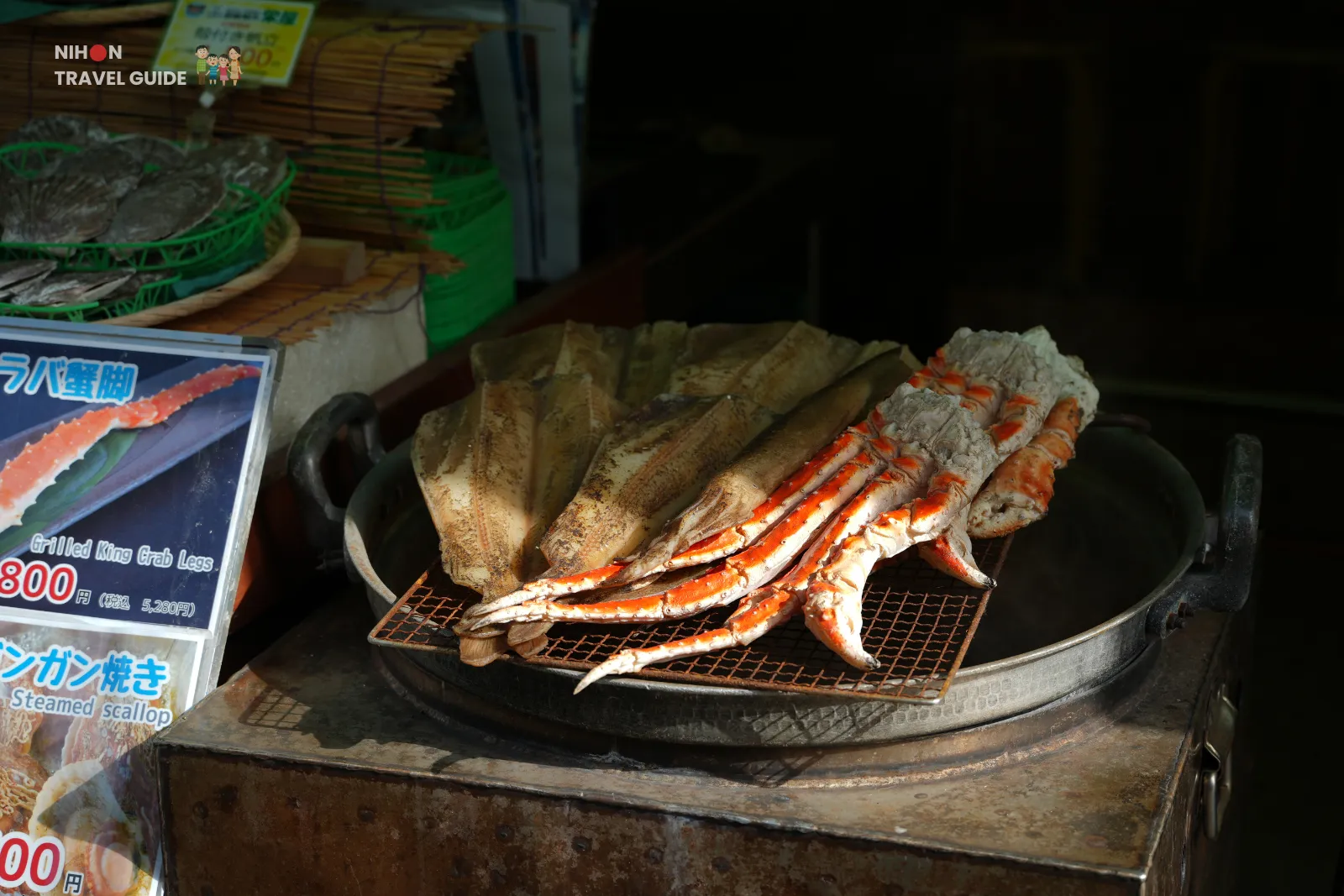 Grilled king crab legs and dried fish arranged on a wire rack over a charcoal grill at Hakodate Morning Market.