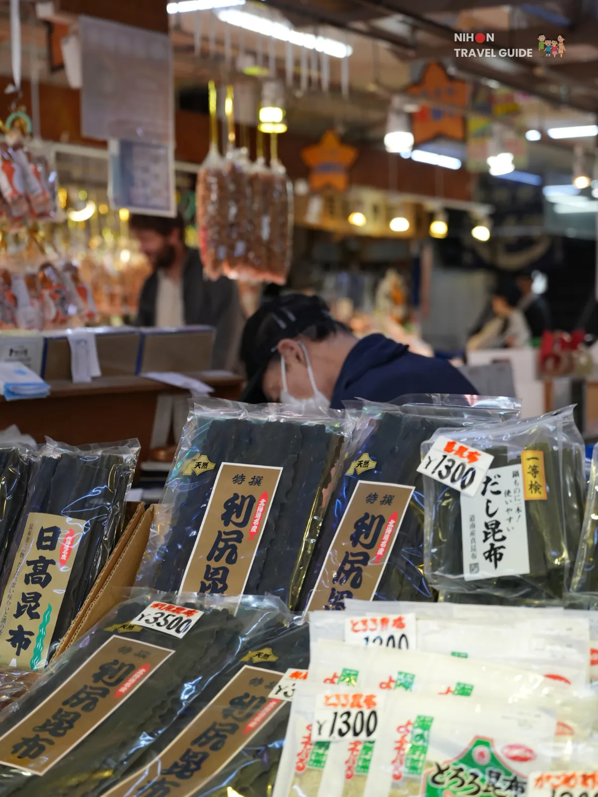 Packages of Hokkaido kombu and hanging dried snacks at a stall in Hakodate Morning Market.