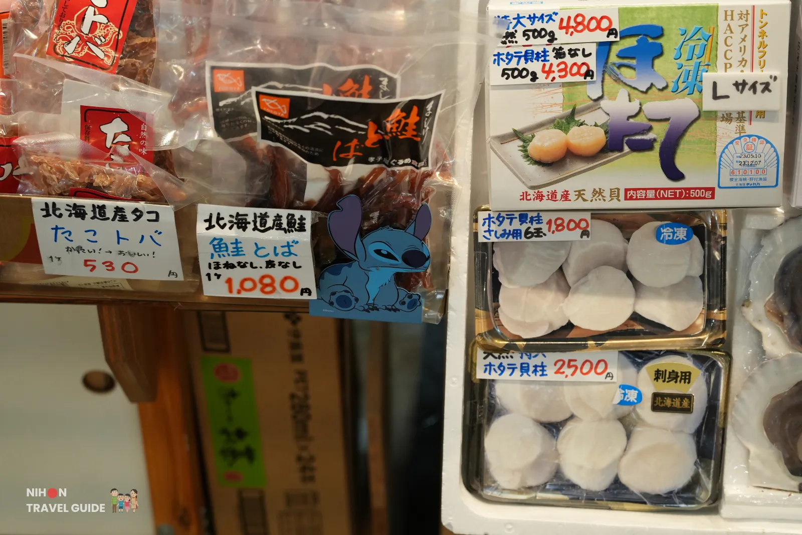 Packaged Hokkaido scallops and dried seafood snacks with handwritten price tags at Hakodate Morning Market.