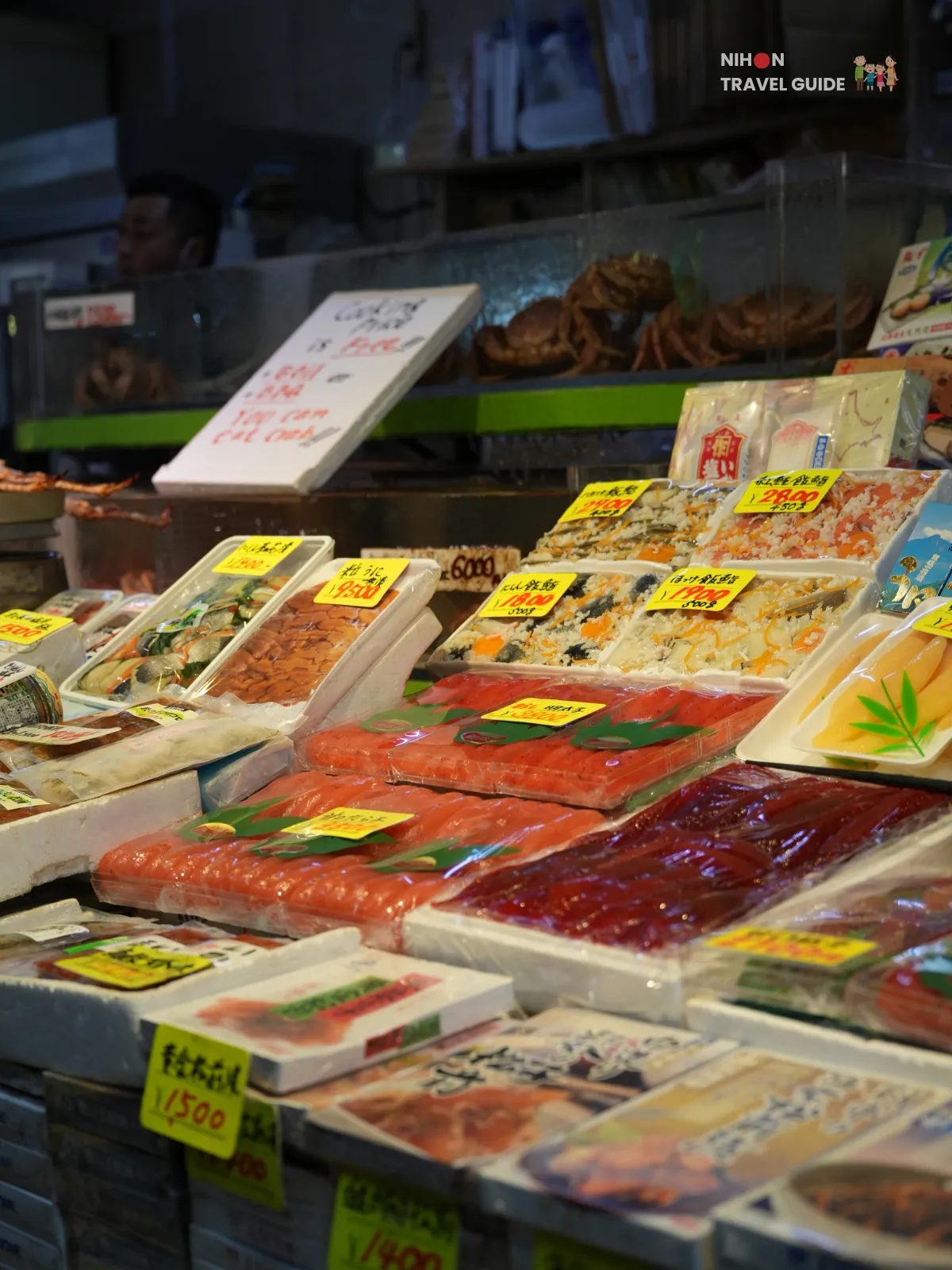 Assorted salmon fillets and seafood neatly packed in trays with yellow price tags at Hakodate Morning Market.