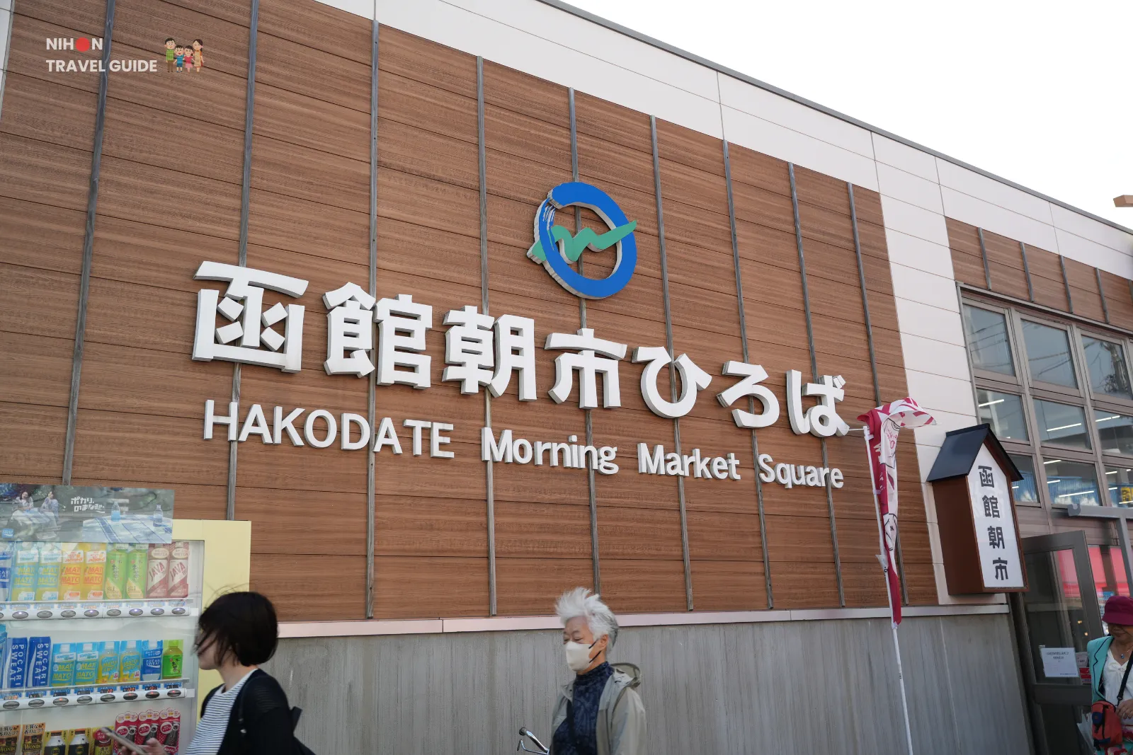 hakodate-morning-market-square-sign Entrance sign for Hakodate Morning Market Square with Japanese lettering on a wooden wall.