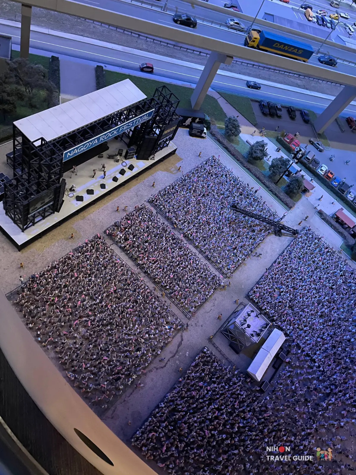 Close-up of the SCMaglev and Railway Park diorama depicting the Nagoya Rock Festival stage and a densely packed crowd of miniature figures.