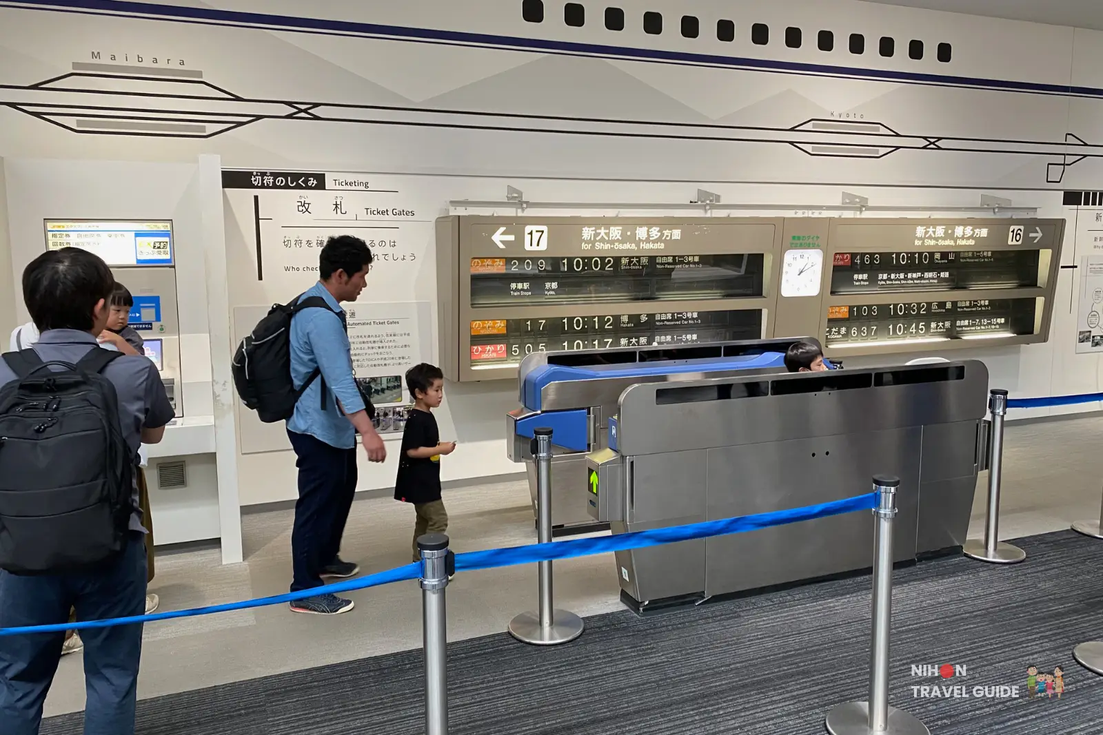 Interactive exhibit showing Shinkansen ticket machines, departure boards, and an automatic ticket gate with visitors trying it out at SCMaglev and Railway Park.