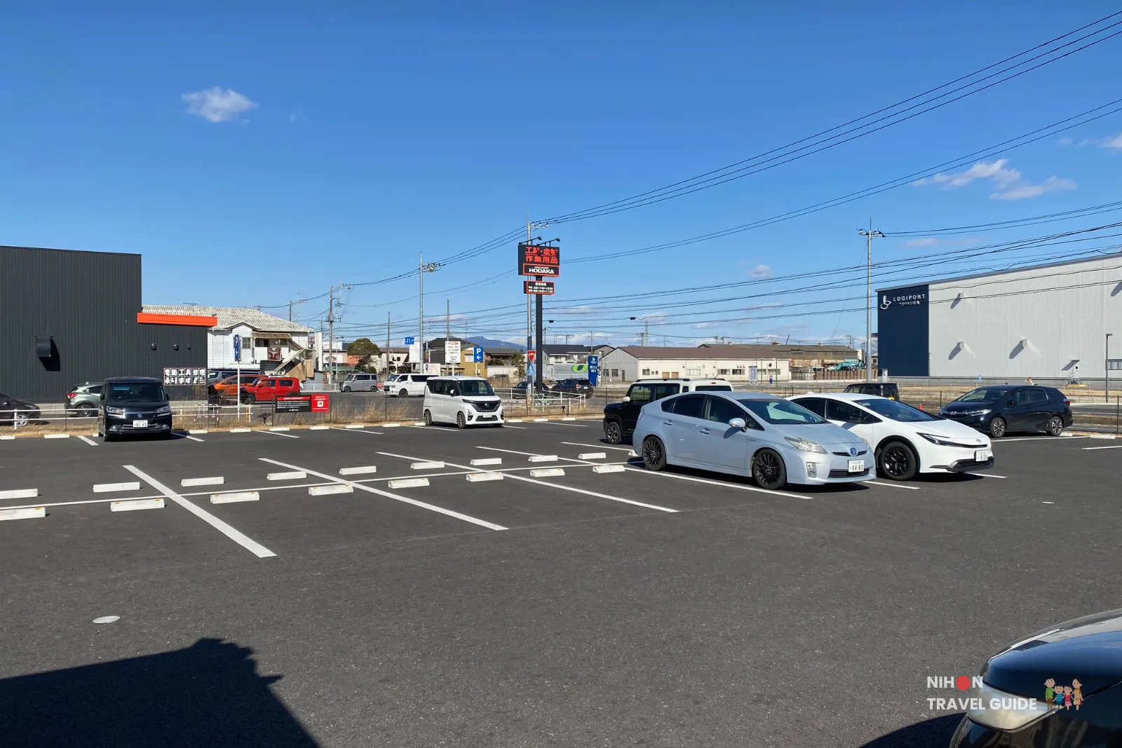 Spacious outdoor parking lot at Hotel R9 The Yard Tsukuba with several parked cars on a sunny day.