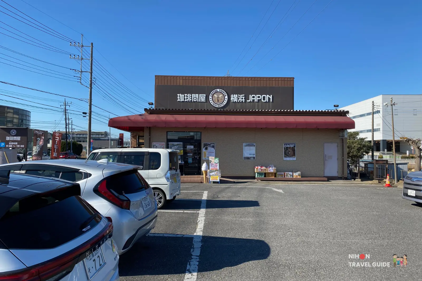Exterior of Tonya Coffee shop in Tsukuba with cars parked in front under a clear blue sky.