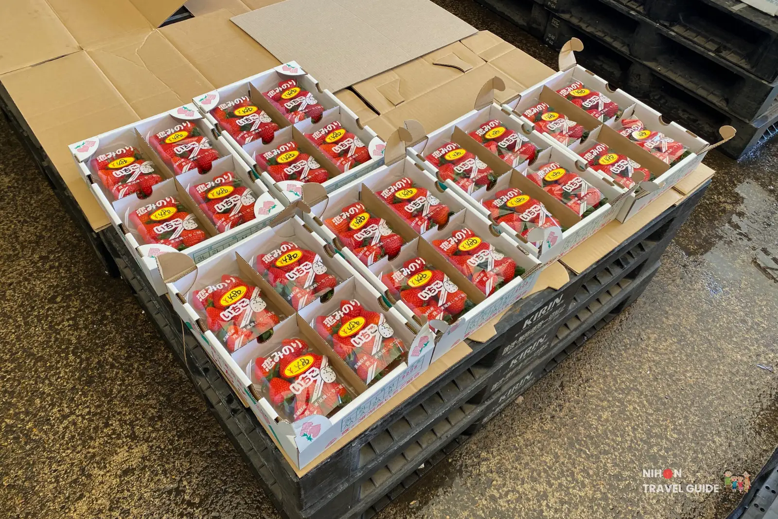 Crates of fresh "Hohoemi no Ichigo" (Smiling Strawberries) packed in heart-decorated boxes at Tsuchiura Fish Market main hall, seasonal produce display.