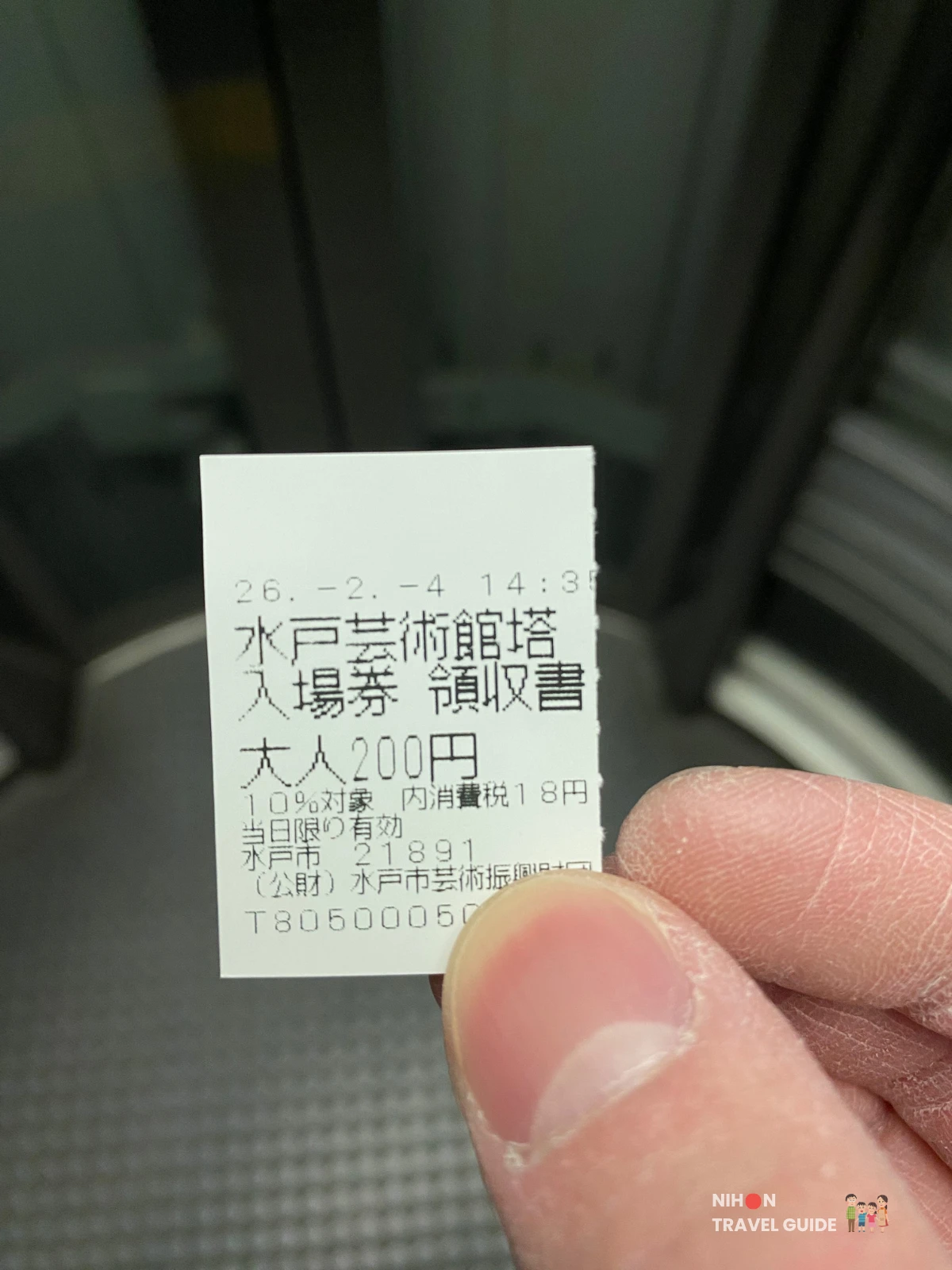 Hand holding the Art Tower Mito observation tower admission ticket receipt showing the adult price of ¥200 including 10% consumption tax, valid on the day of purchase only, issued by the Mito City Arts Promotion Foundation, Ibaraki, Japan