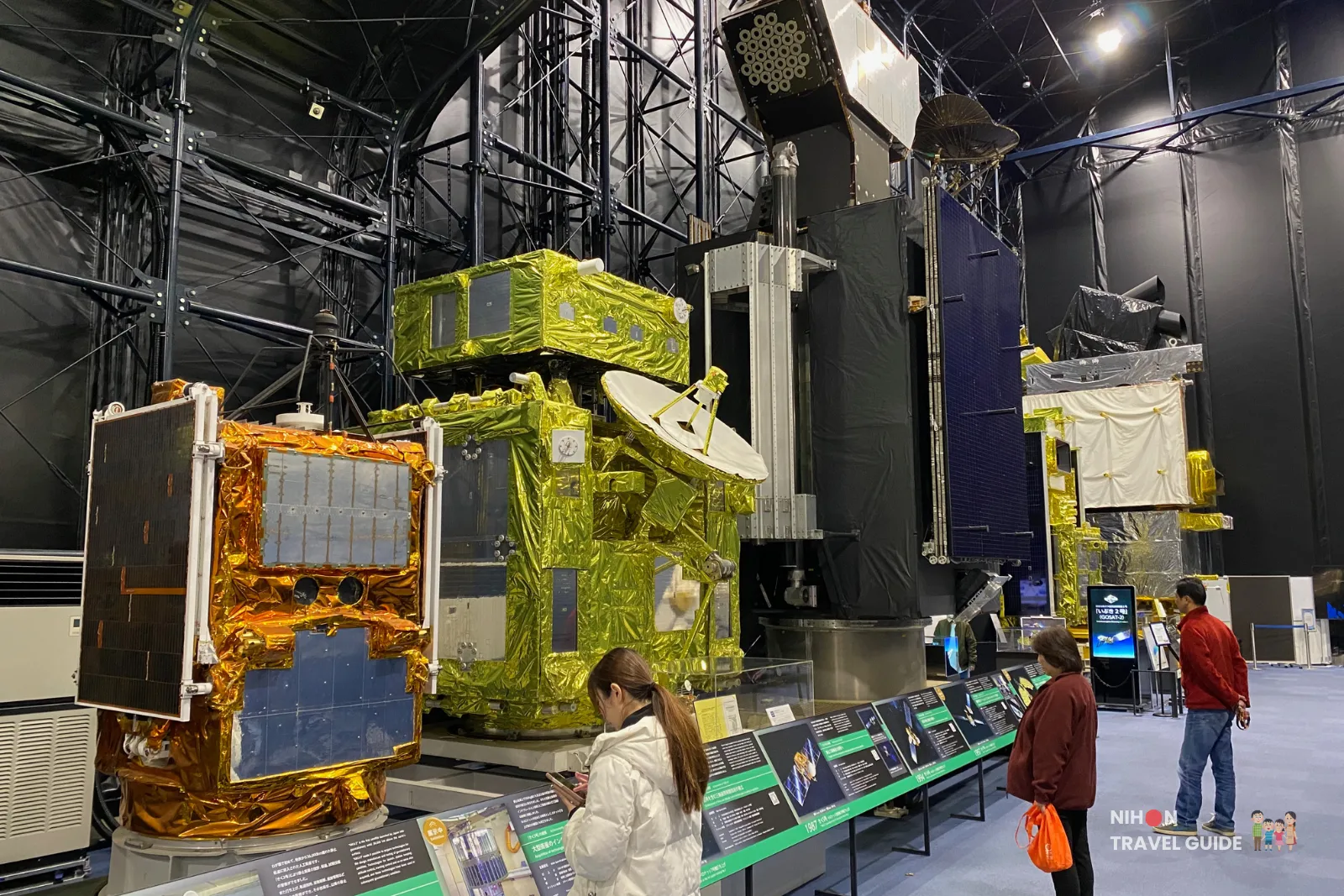 A few large JAXA communications satellites model with gold thermal blankets and parabolic antenna at Tsukuba Space Center Space Dome.