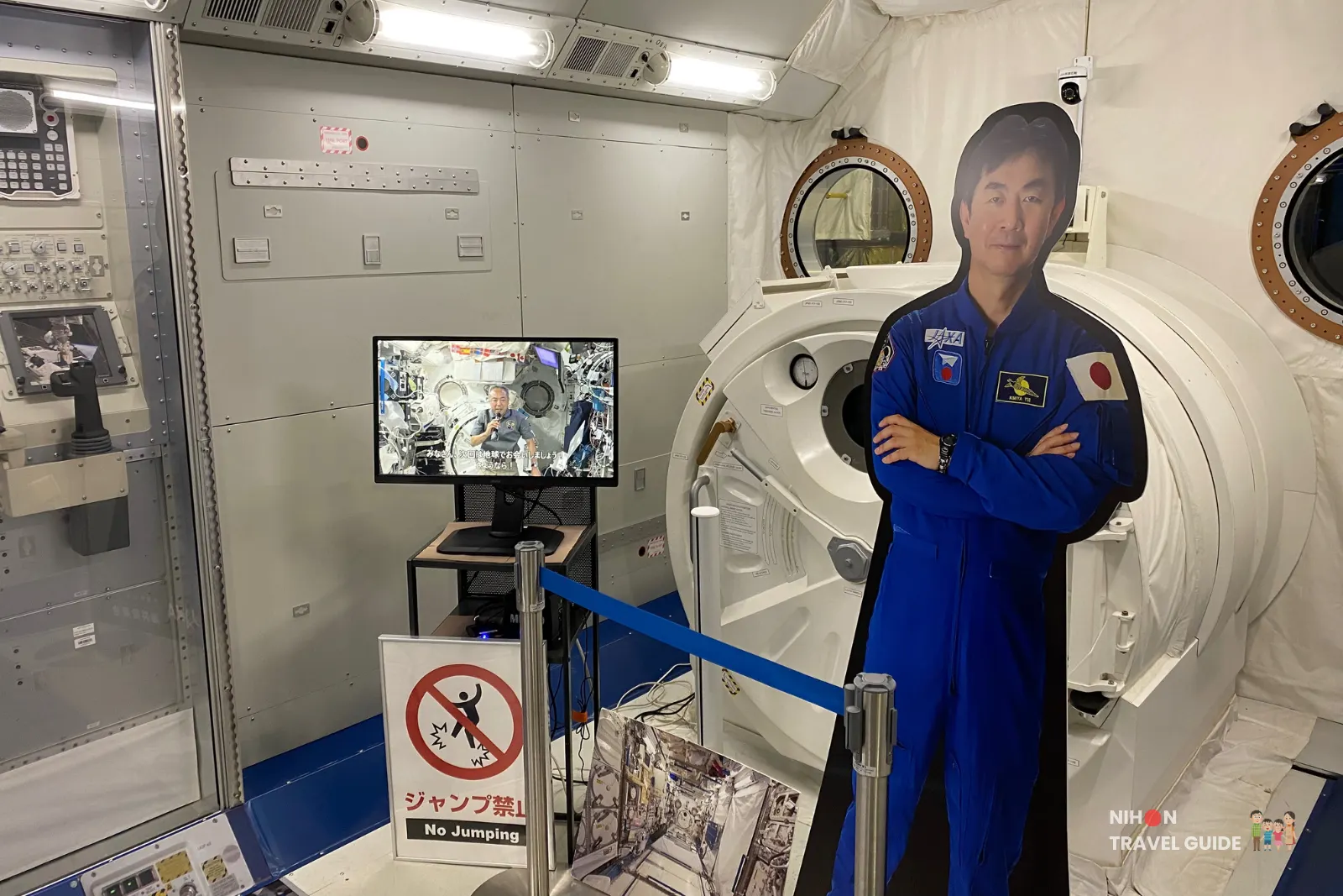 Interior display of the JAXA Kibō module at Tsukuba Space Center with an astronaut cutout, circular hatch and monitor showing life aboard the ISS.