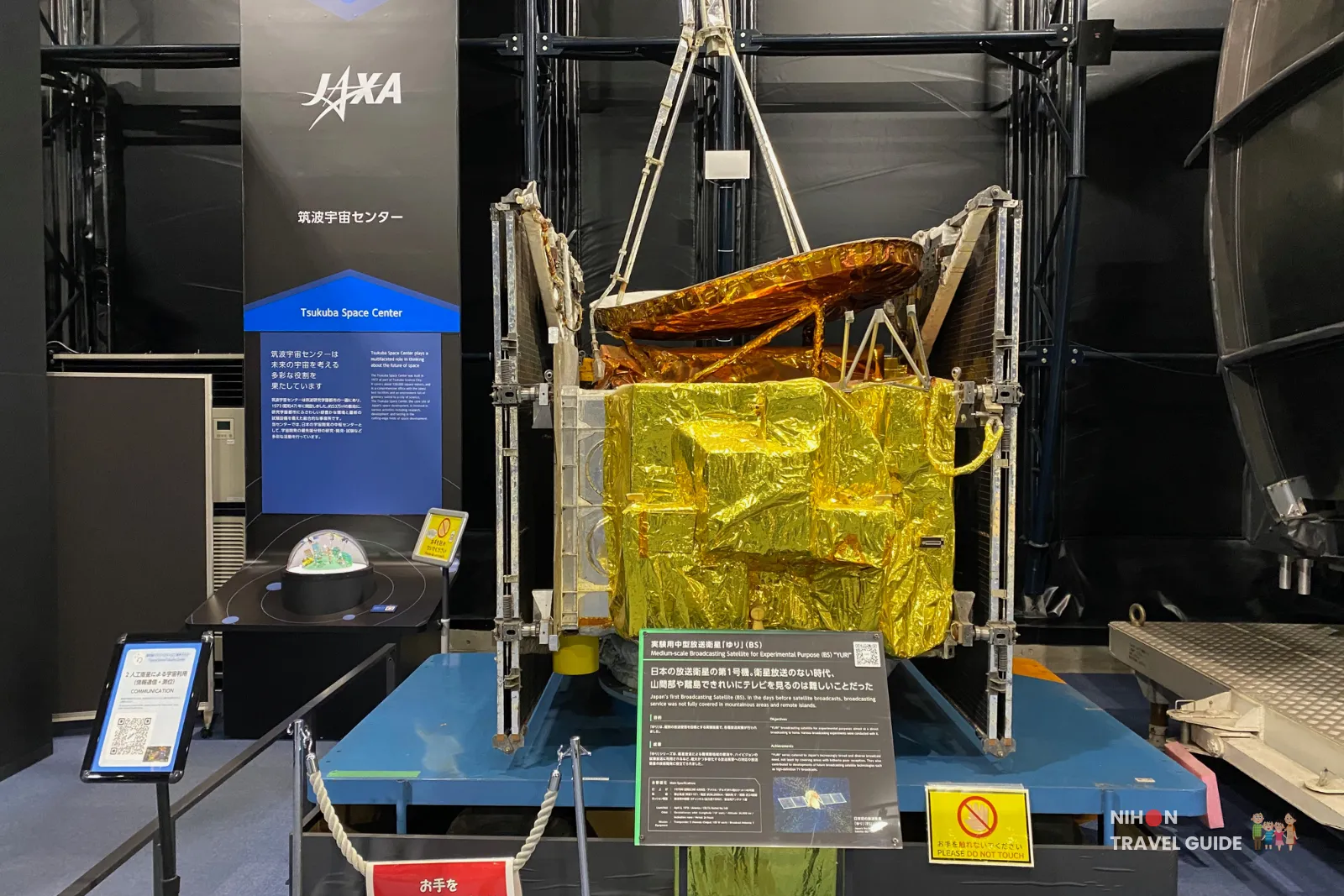 Model of the BS ‘Yuri’ broadcasting satellite wrapped in gold thermal foil on display inside the Space Dome at JAXA Tsukuba Space Center.