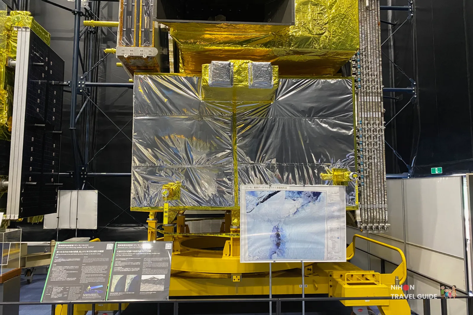 Full-scale model of JAXA’s ALOS-2 ‘Daichi-2’ Earth observation satellite wrapped in silver and gold thermal foil with a sample radar image display inside the Space Dome at Tsukuba Space Center.