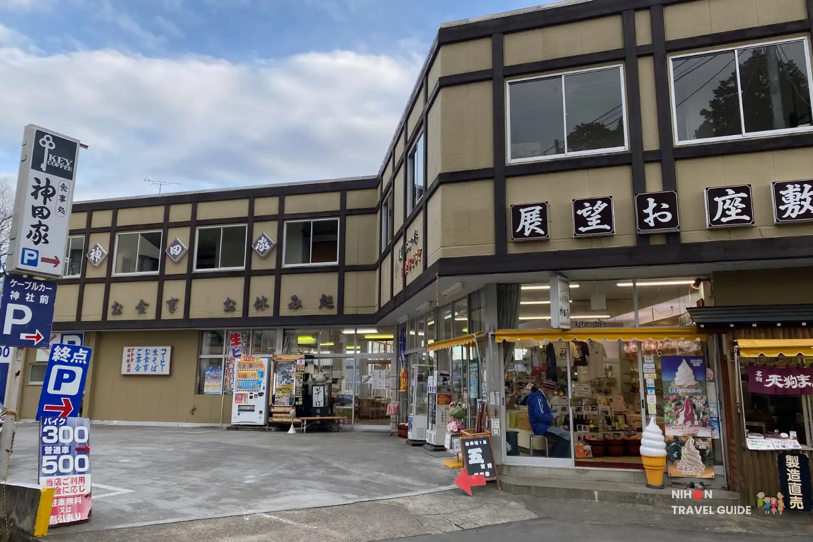 Front view of Kandaya, a souvenir shop and casual restaurant near Tsukubasan Shrine, with vending machines and parking area in front.