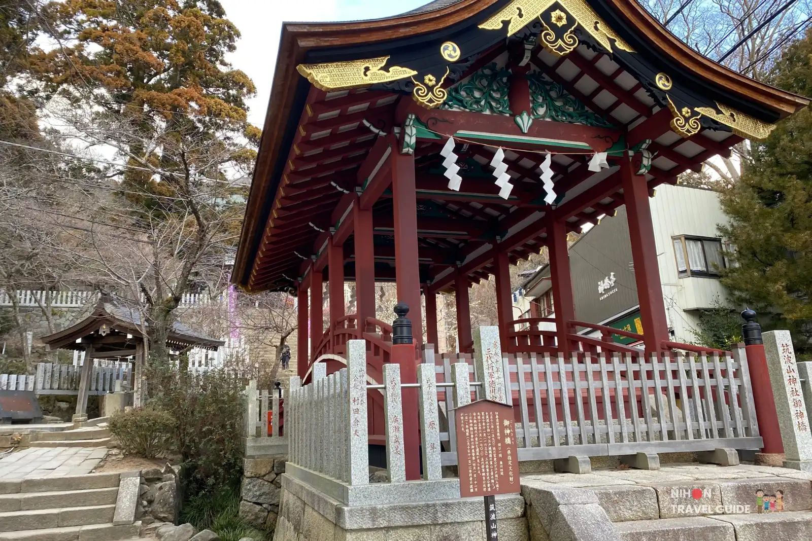 Red-lacquered Shinkyō sacred bridge pavilion at Tsukubasan Shrine, marking the transition into the inner precincts.