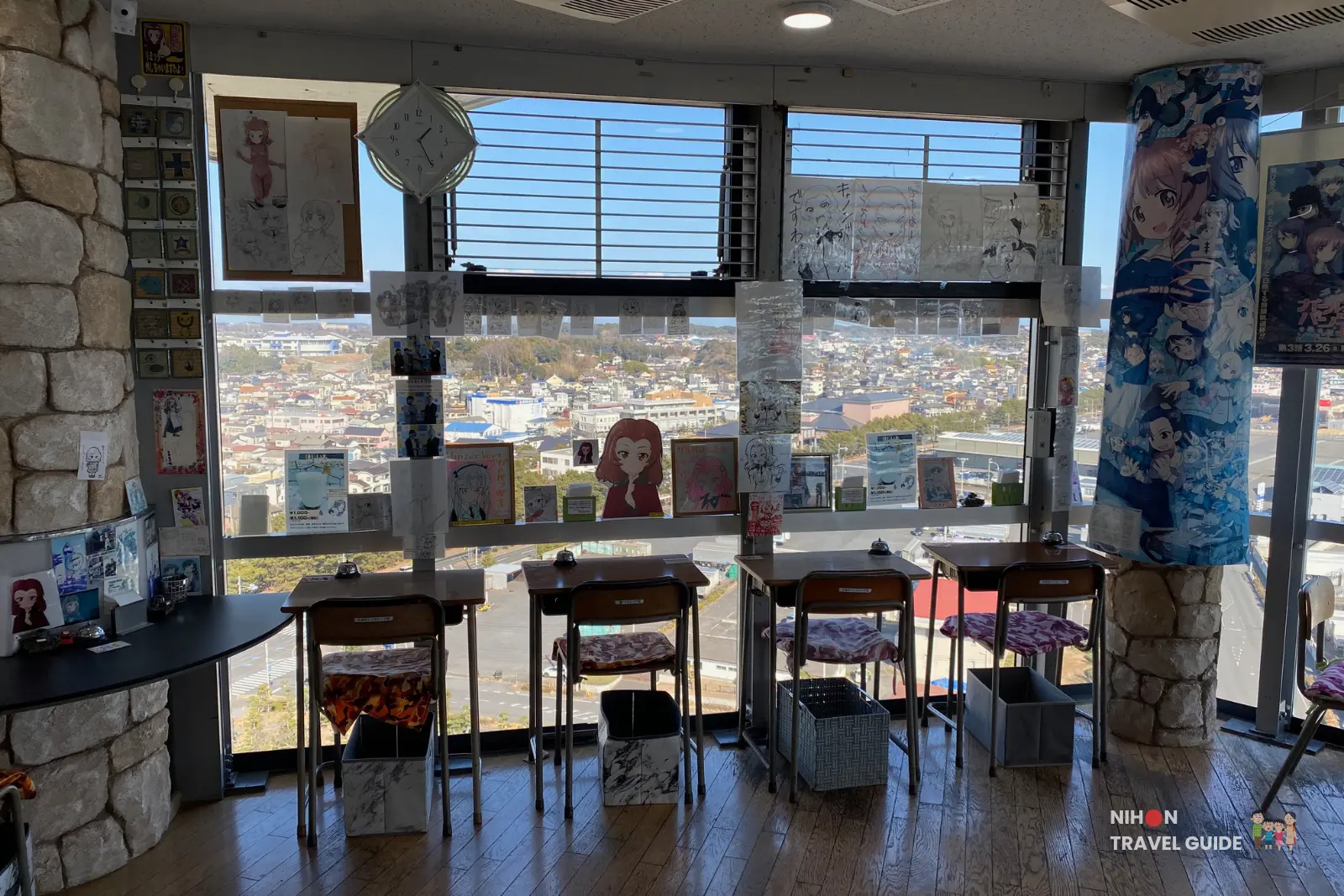 Unique school desk seating arranged in front of huge windows at Café Panzer Vor inside Oarai Marine Tower, offering a wide view over Oarai town and the Pacific Ocean, decorated with anime artwork, Japan