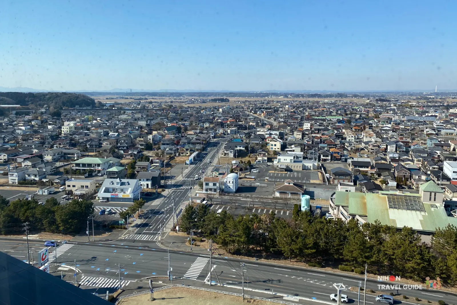 oarai-marine-tower-observation-deck-southwest-town-and-roads Detailed southwest view from the top of Oarai Marine Tower overlooking Oarai town, intersections, parking areas, and suburban houses with mountains visible on the horizon, Ibaraki, Japan