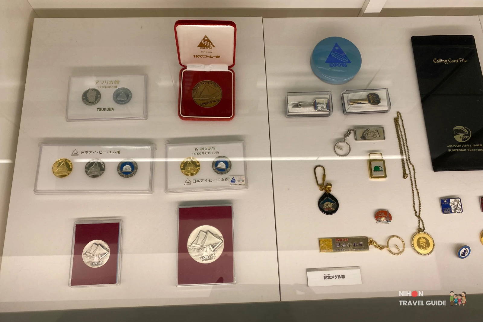 Display of official commemorative medals, coins, and special items from the 1985 Tsukuba International Science and Technology Exposition.