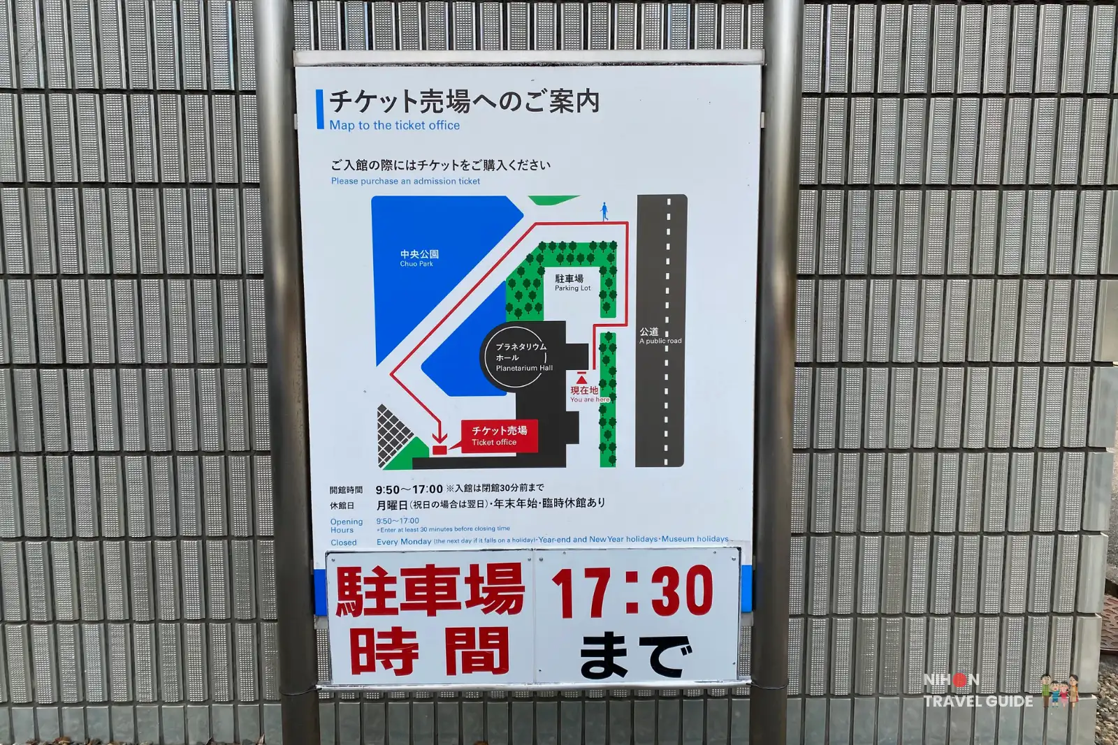 Directional map at Tsukuba Expo Center showing the location of the ticket office, Planetarium Hall, parking lot, and main entrance. Includes opening hours and closing time information.