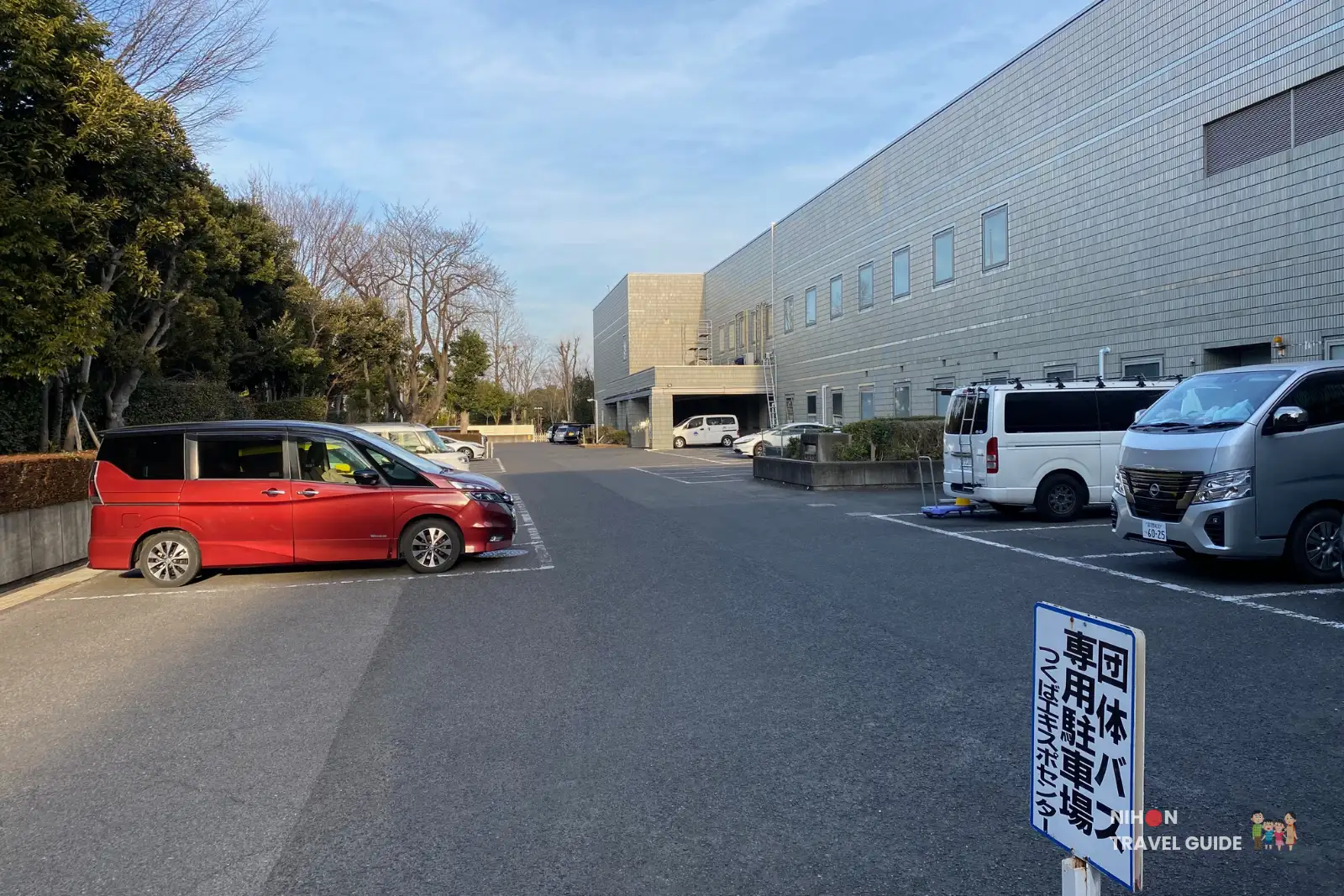 Parking lot at Tsukuba Expo Center with visitor vehicles. The facility offers parking close to the main building for easy access.