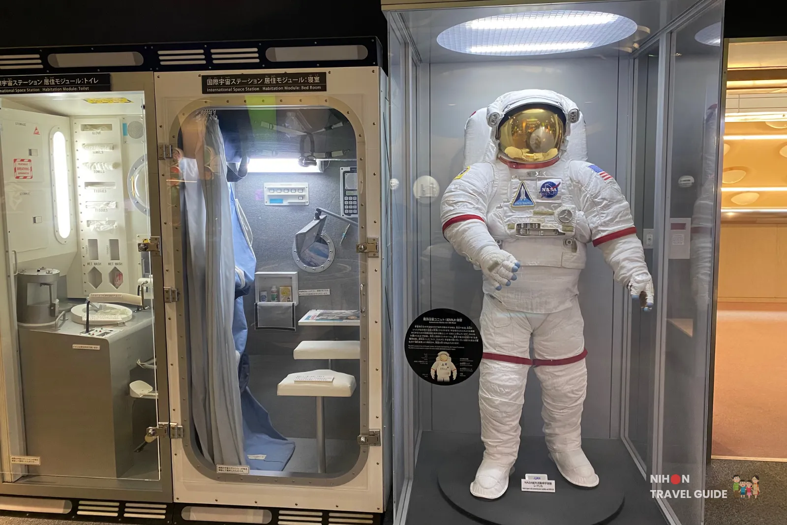 Display on the second floor featuring a full NASA/JAXA-style astronaut suit next to a detailed mock-up of the International Space Station habitation module (toilet and living quarters).