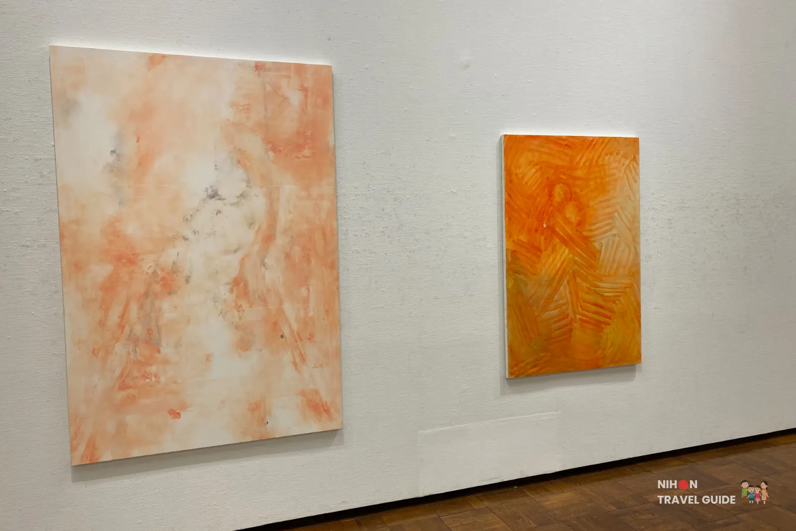 Two large abstract paintings on the gallery wall — left: soft peach and white swirling marbled composition; right: vibrant orange with energetic hatched linear patterns.