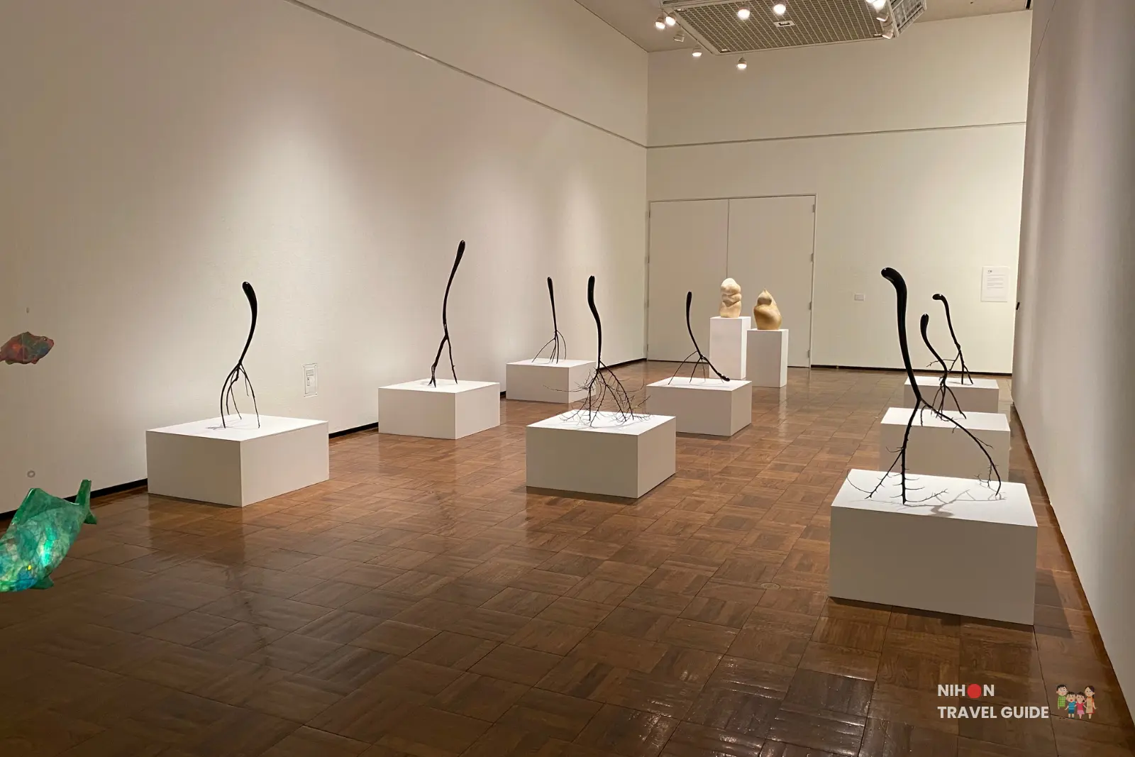 Wide view of the black wire/branch sculpture installation arranged on multiple white pedestals throughout the sculpture gallery at Tsukuba Museum of Art
