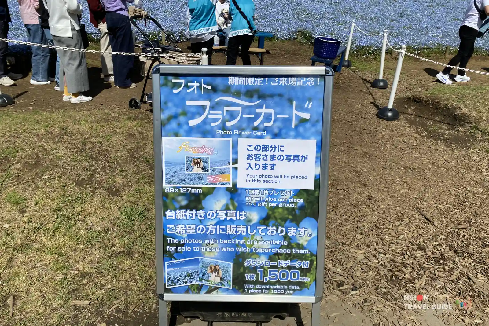 Photo Flower Card service sign at the Nemophila fields in Hitachi Seaside Park. Visitors can get a free commemorative photo card with the blue flower background.