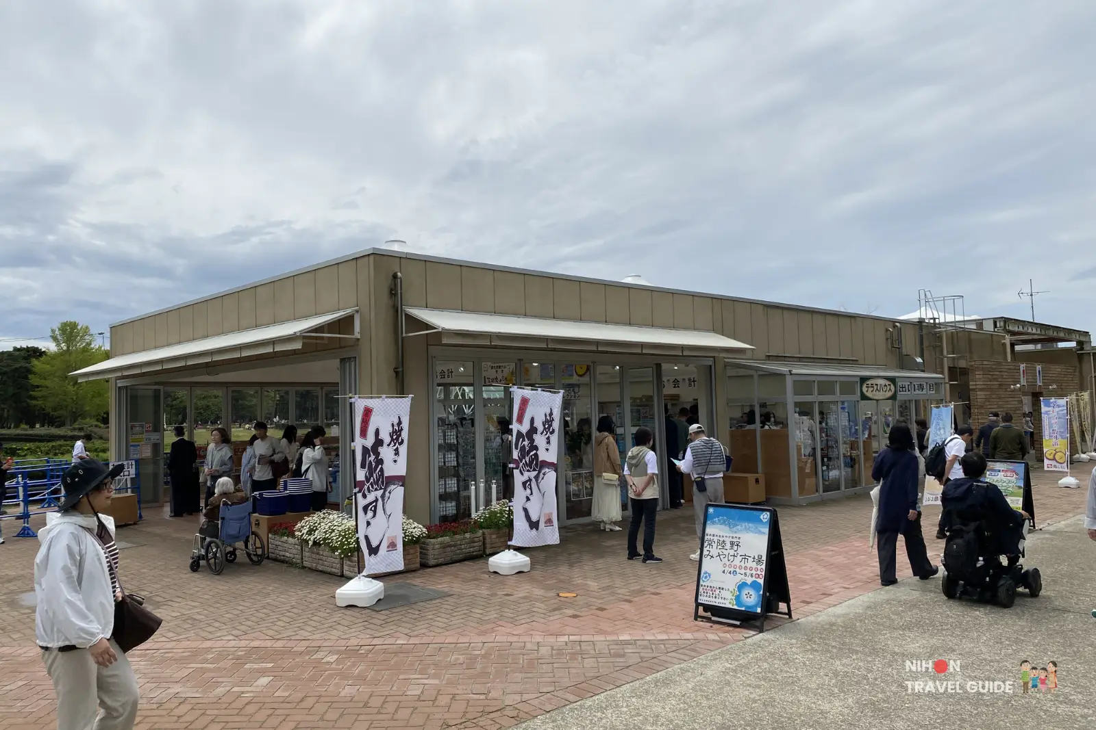 Restaurant and shop building at Hitachi Seaside Park offering yakisoba and other Japanese meals, with visitors waiting outside during the spring season.