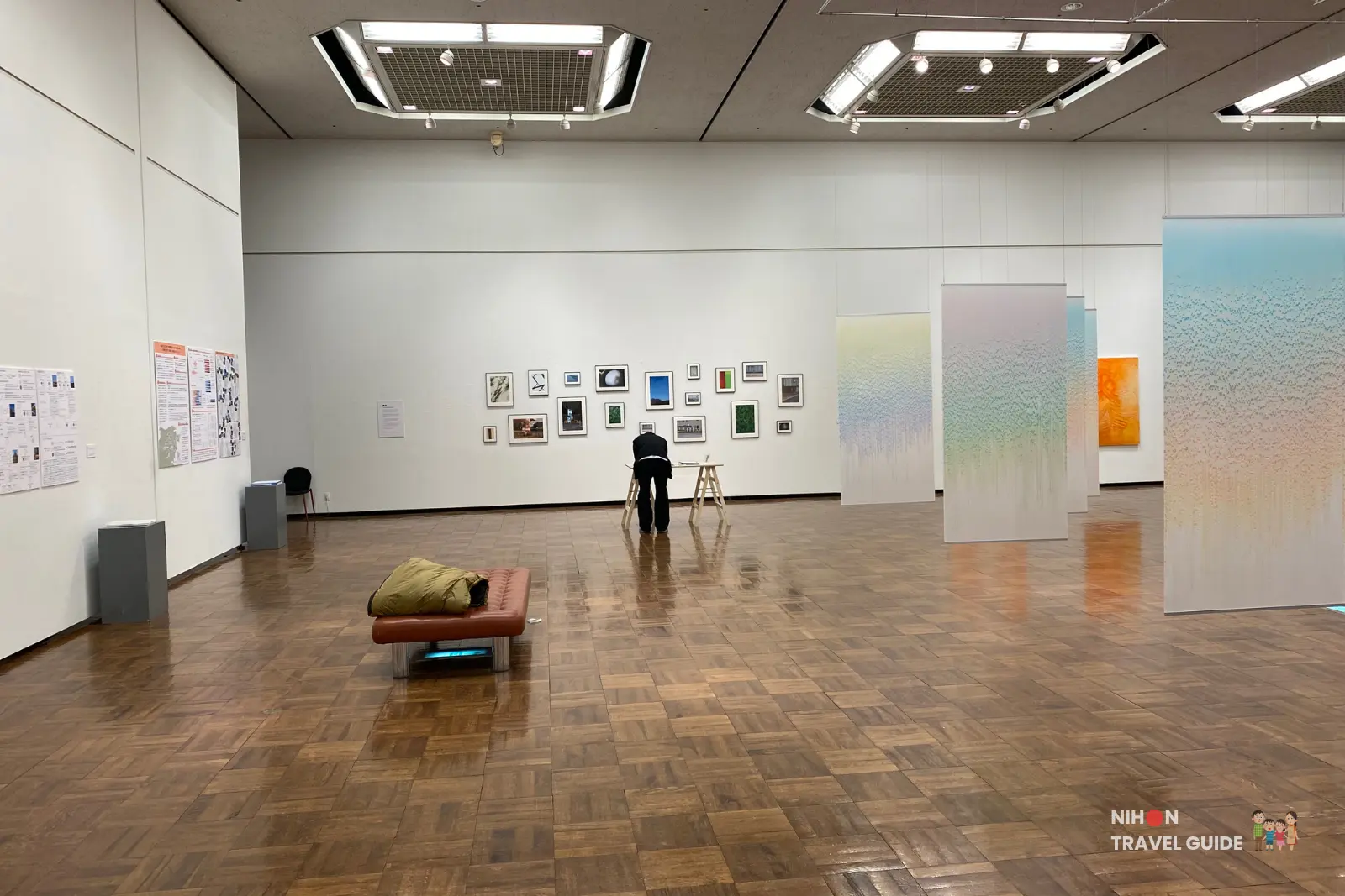 Wide view of the main gallery at Tsukuba Museum of Art showing Flow hanging gradient panels by Saya Takama on the right and the My room \ My story photography wall on the left