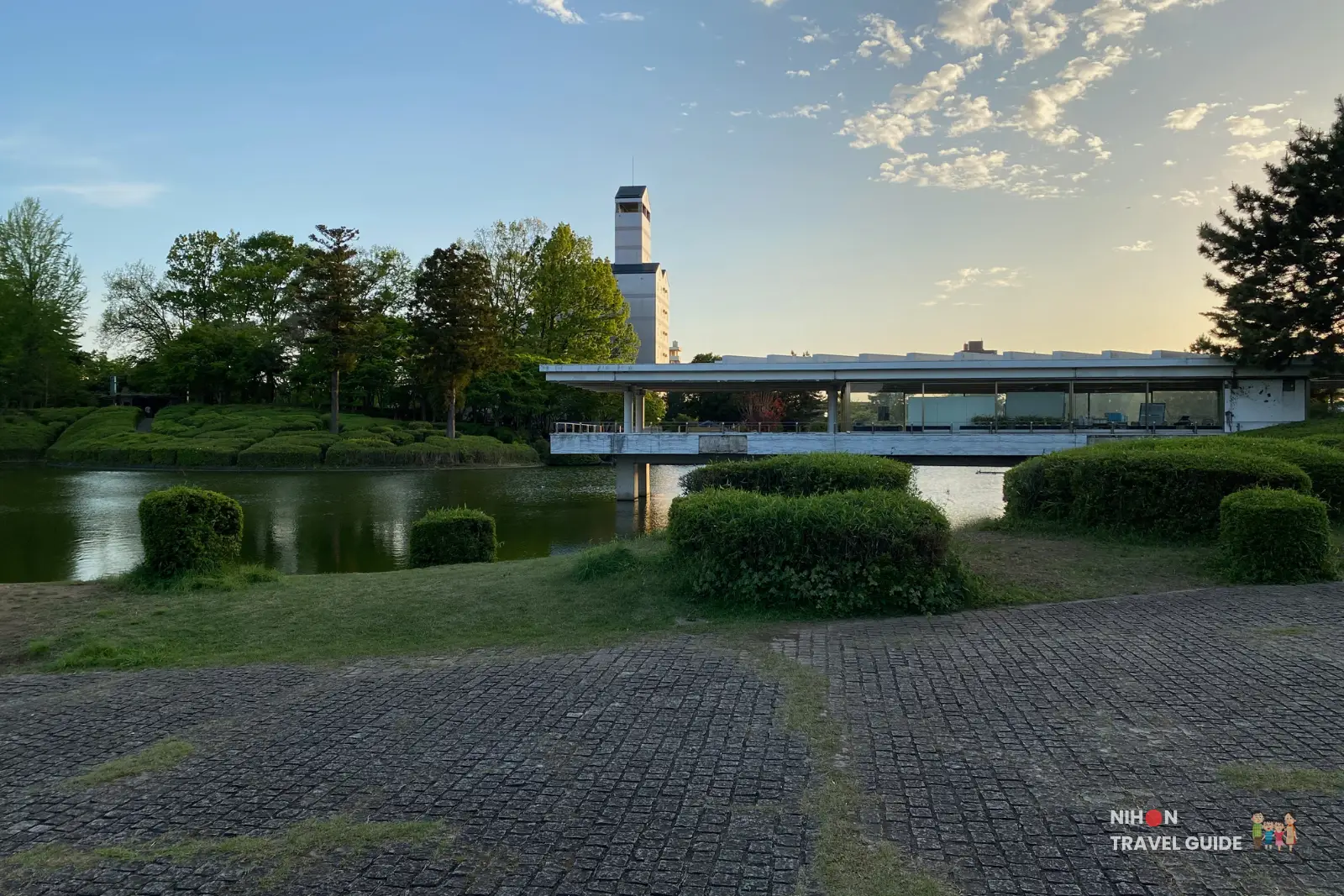 Modern bridge crossing the pond at Matsumi Park, Tsukuba with the tower visible in the distance.
