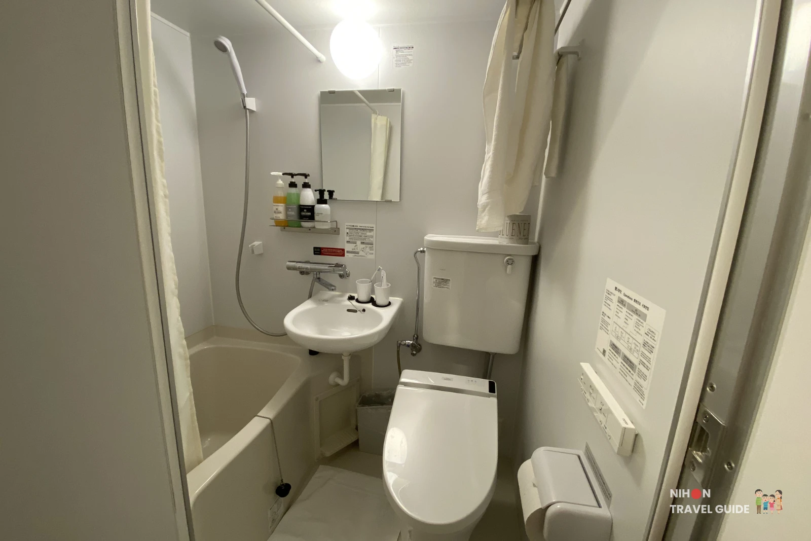 Full view of the clean and compact bathroom with toilet, sink, bathtub, and shower at R9 The Yard Hotel Hitachinaka Ichige