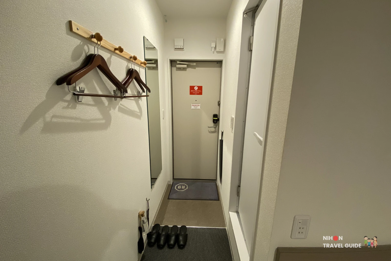 Clean and compact entryway of Room 23 at R9 The Yard Hotel Hitachinaka Ichige with coat hangers, mirror, and slippers