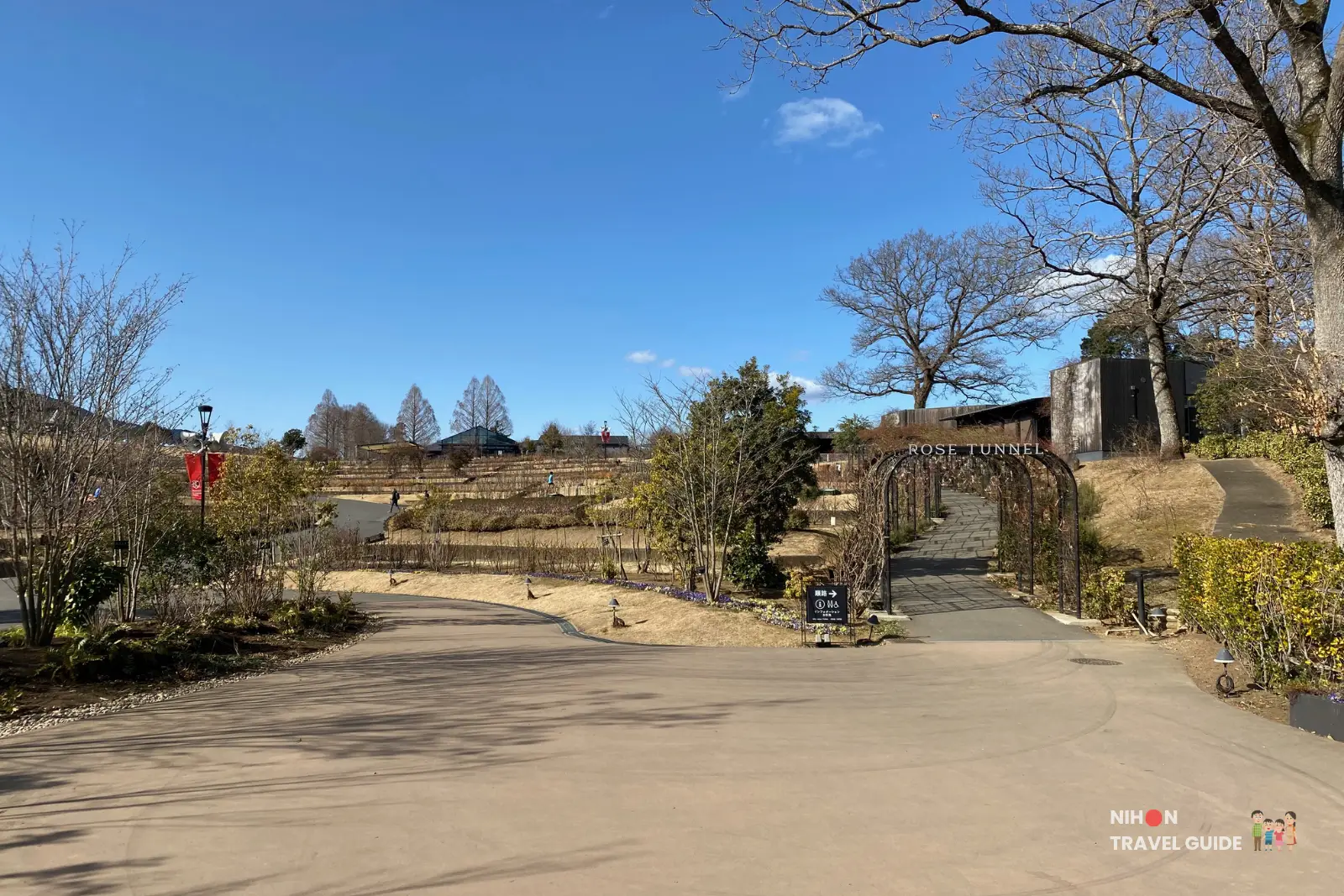 Path leading to the Rose Tunnel at Ibaraki Flower Park on a clear sunny winter day.