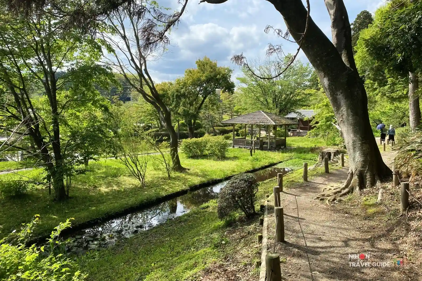 Peaceful stream, gazebo, and lush trees in a scenic area of Kairakuen Garden in Mito.