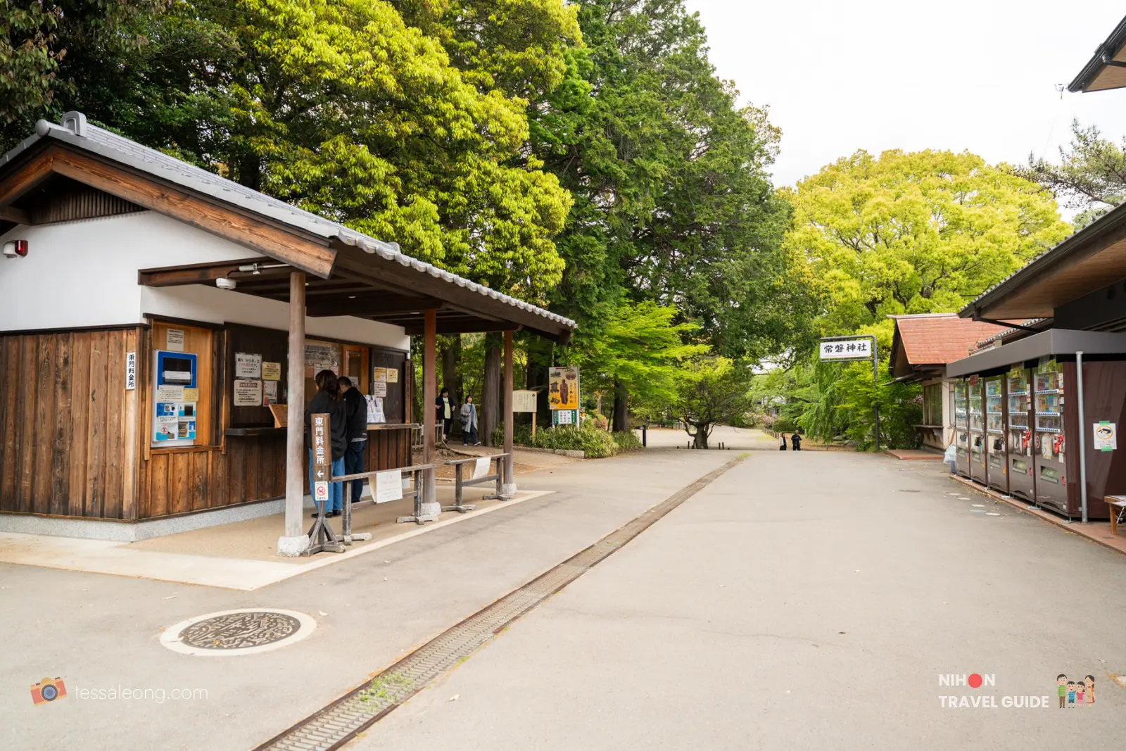 Entrance ticketing booth and information counter at Kairakuen Garden in Mito, with lush green trees and pathways leading into the park.