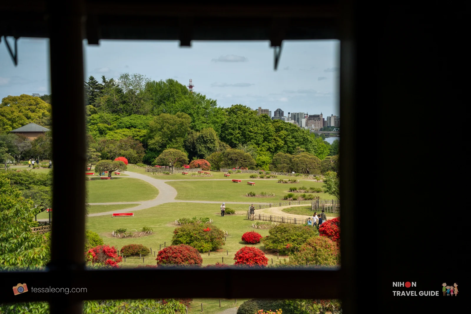 View from inside Kobuntei looking out over the green lawns, paths, and Lake Senba at Kairakuen Garden.