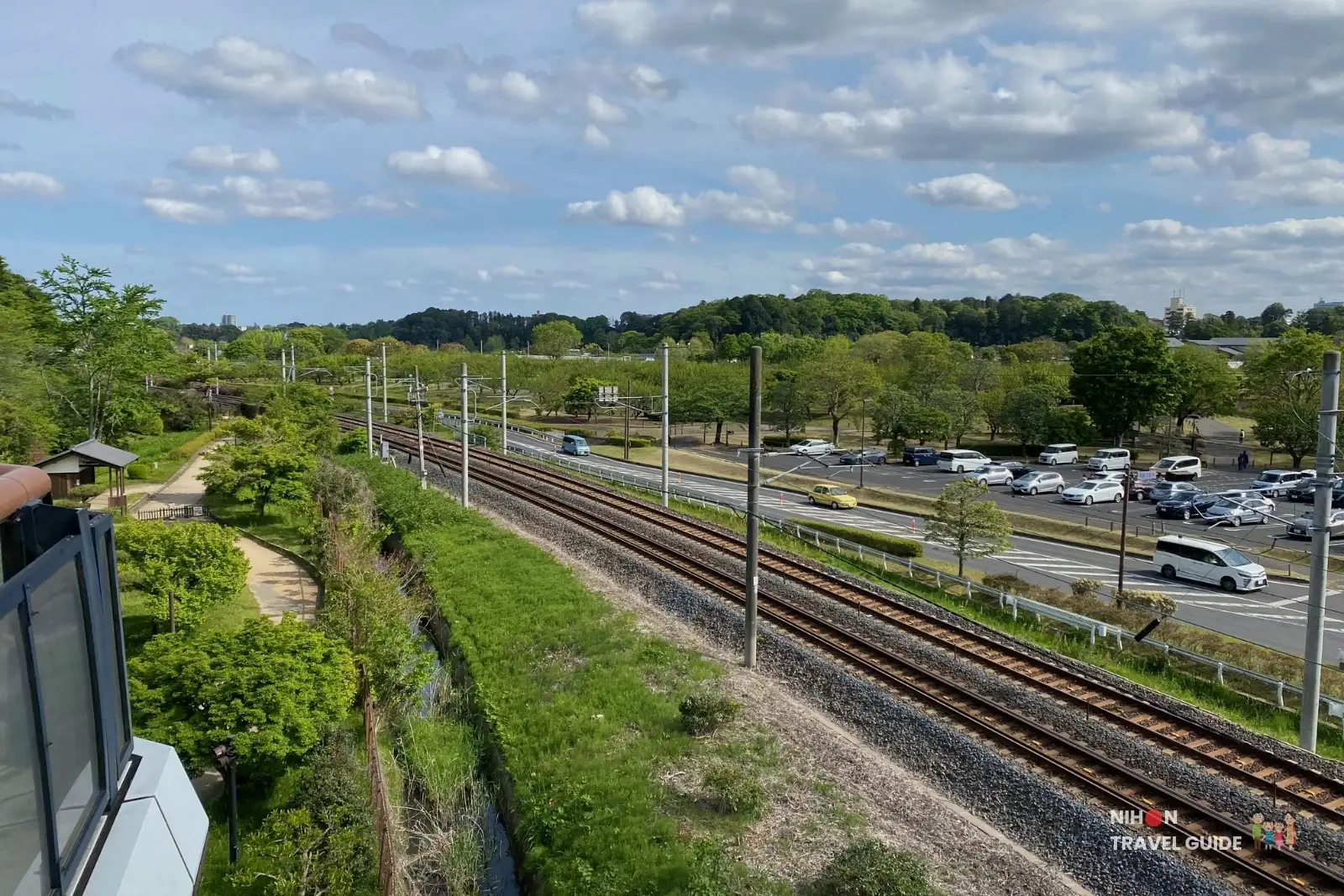 Panoramic view from Kobuntei showing parking areas, Lake Senba, and train tracks near Kairakuen Garden in Mito.