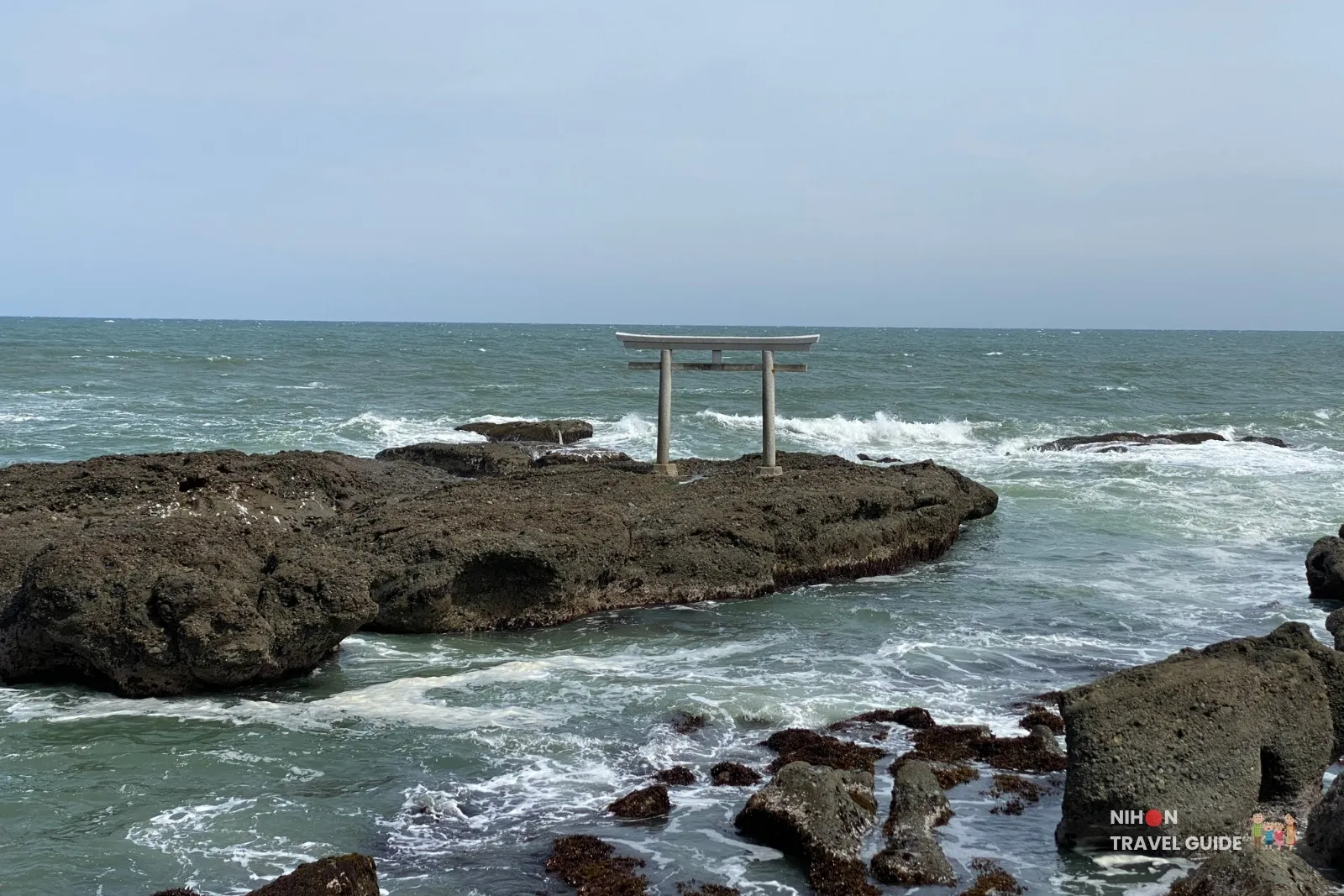 Iconic Kamiiso-no-Torii gate standing on dark rocks in the Pacific Ocean at Oarai Isosaki Shrine, Ibaraki, Japan