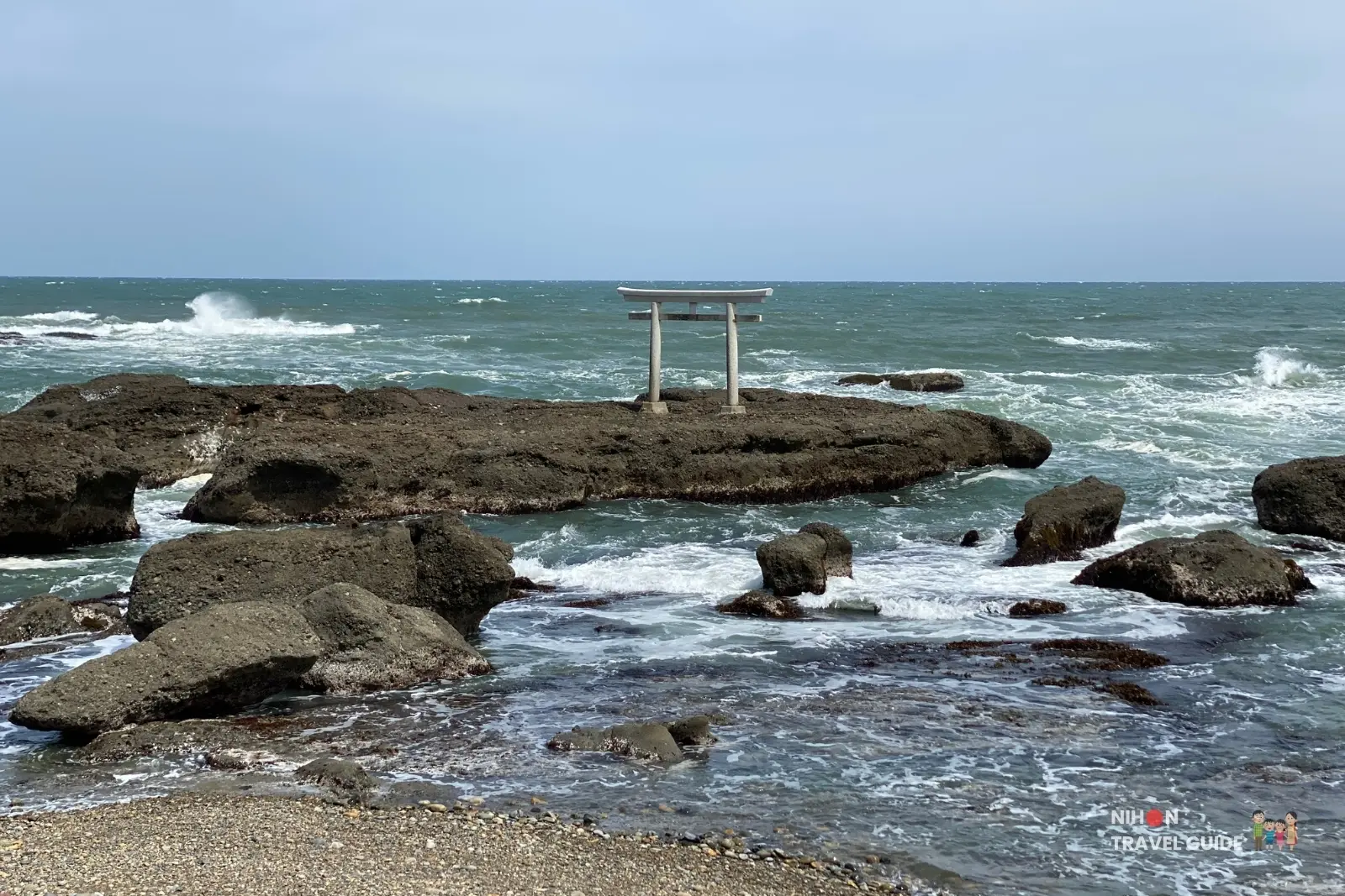 Kamiiso-no-Torii gate standing on dark rocks surrounded by the sea at Oarai Isosaki Shrine in Ibaraki, Japan