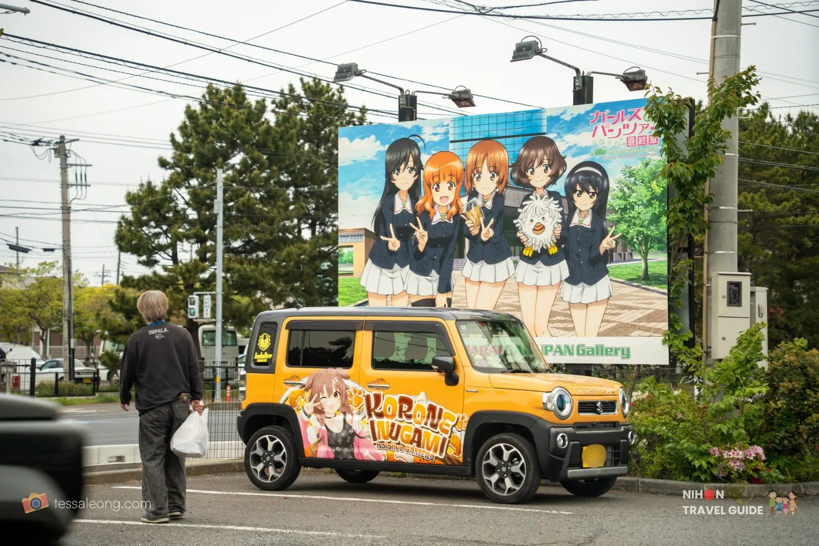 Korone Inugami itasha car parked in front of Girls und Panzer billboard in Oarai Japan