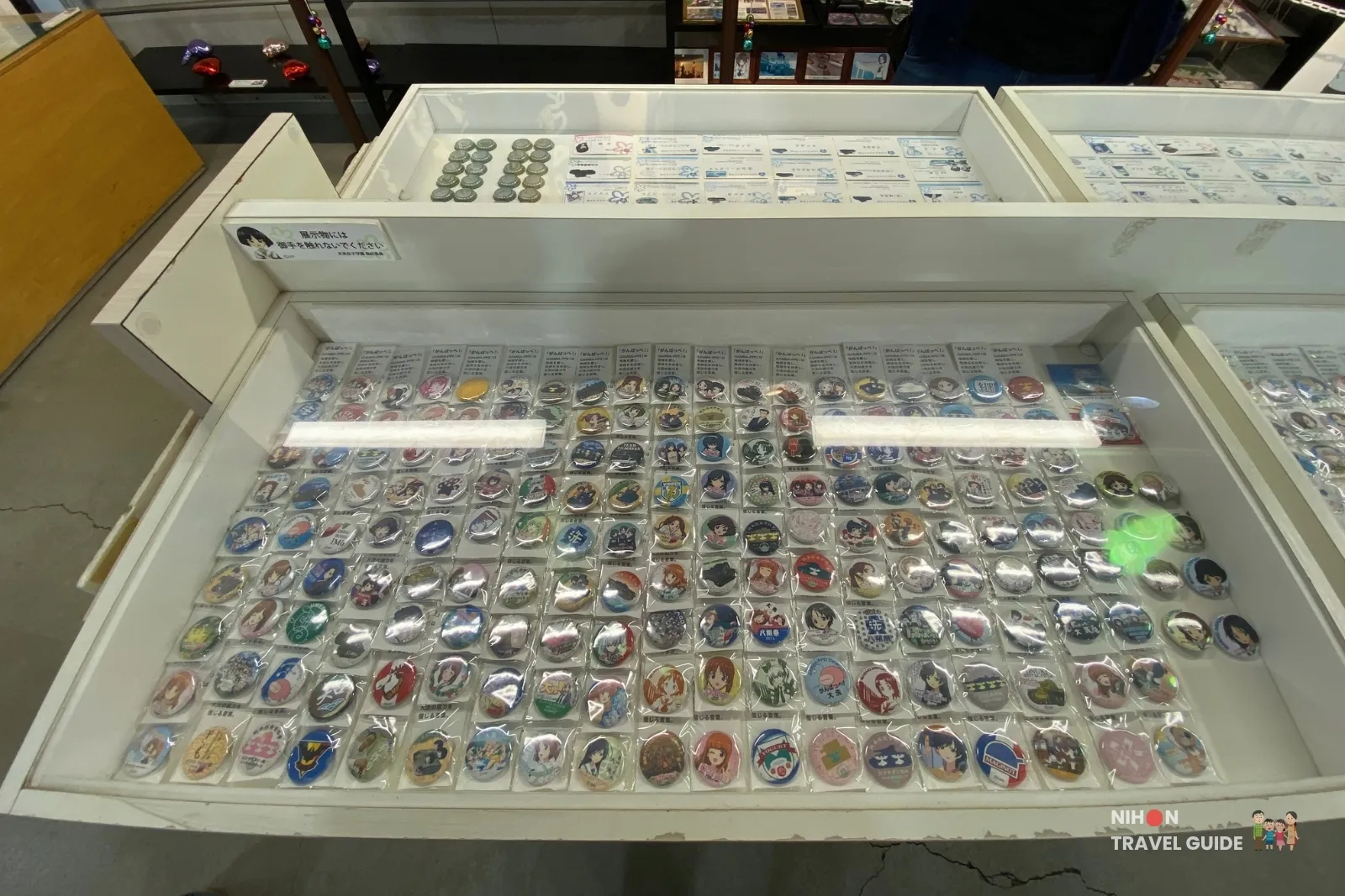 Extensive collection of Girls und Panzer badges and pins on display.