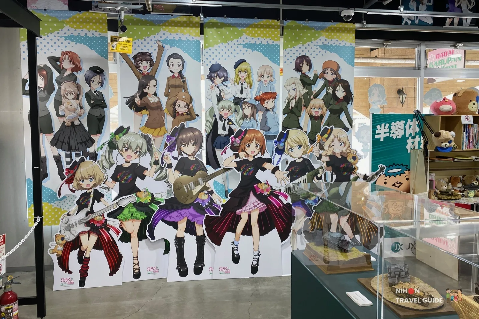 Large Girls und Panzer character cutouts and school banners at Oarai Garupan Gallery.