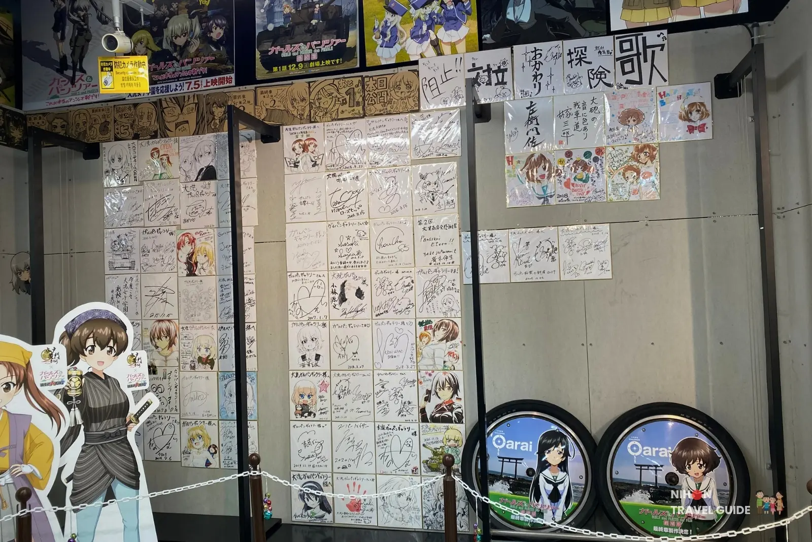 Wall of fan art, signatures, and messages from visitors at Oarai Garupan Gallery.