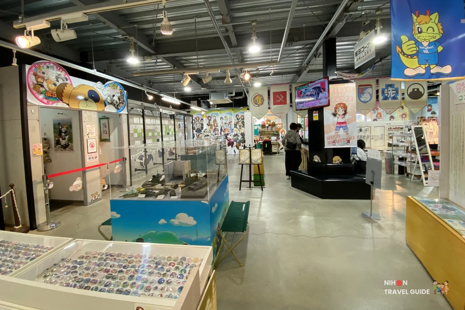 Spacious interior of Oarai Garupan Gallery with hanging banners, displays, and merchandise.