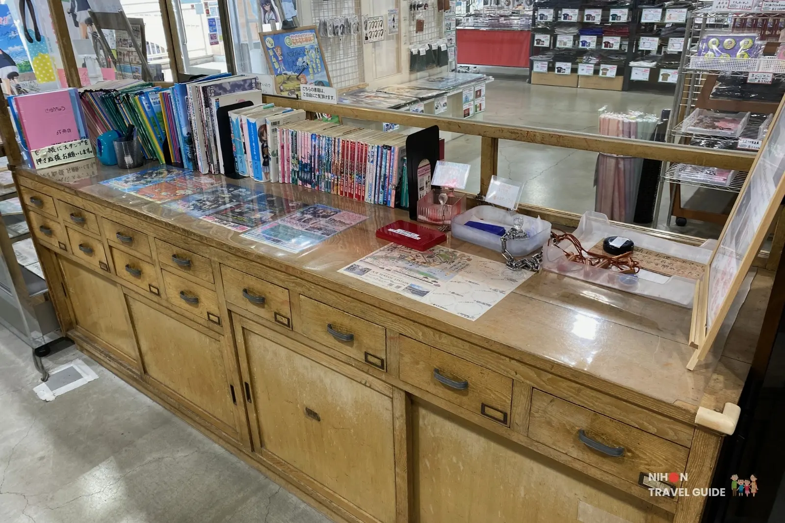 Wooden counter displaying manga books and stamp rally materials in Oarai Garupan Gallery