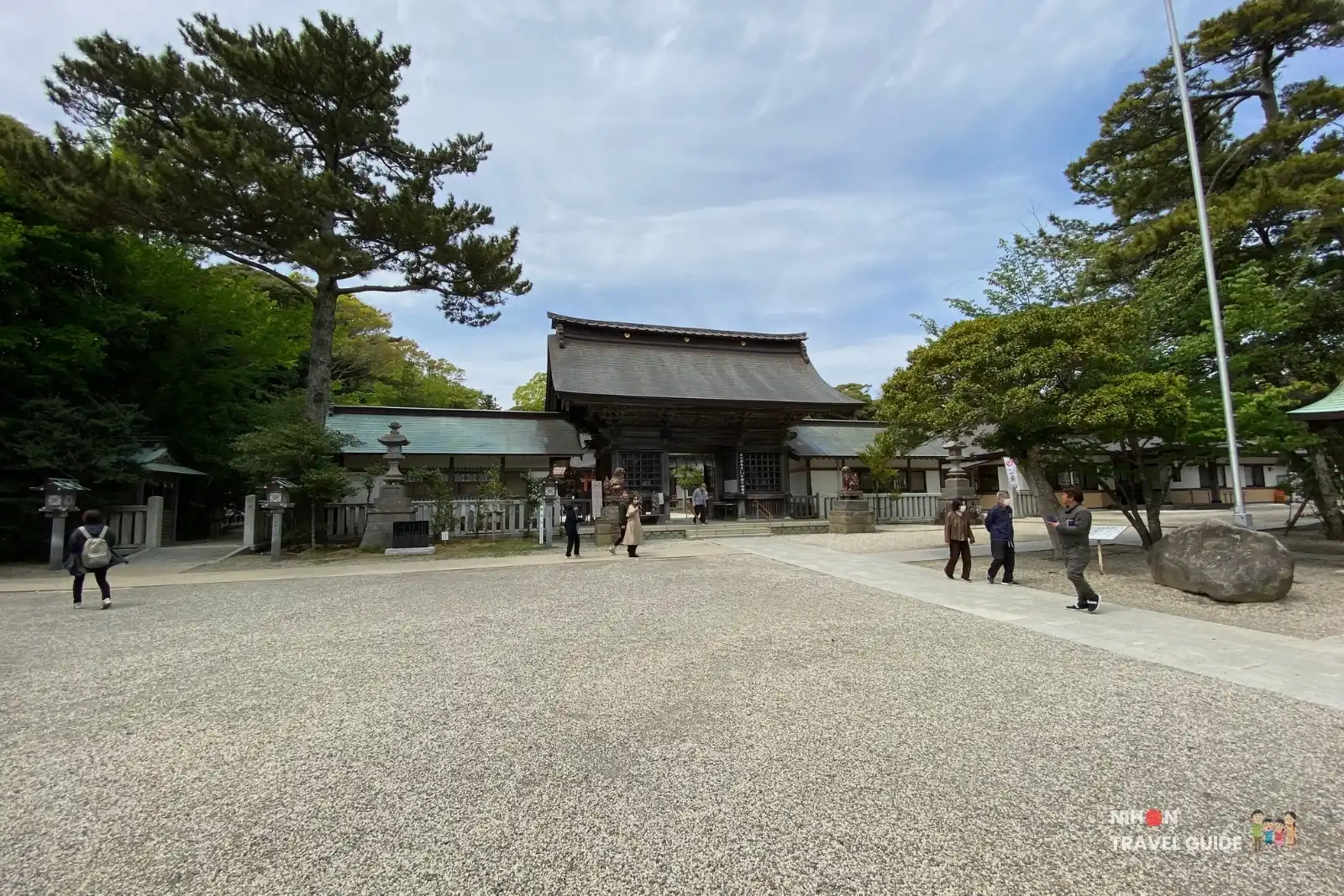 Spacious shrine courtyard with the main worship hall and Japanese flag at Oarai Isosaki Shrine in Ibaraki, Japan