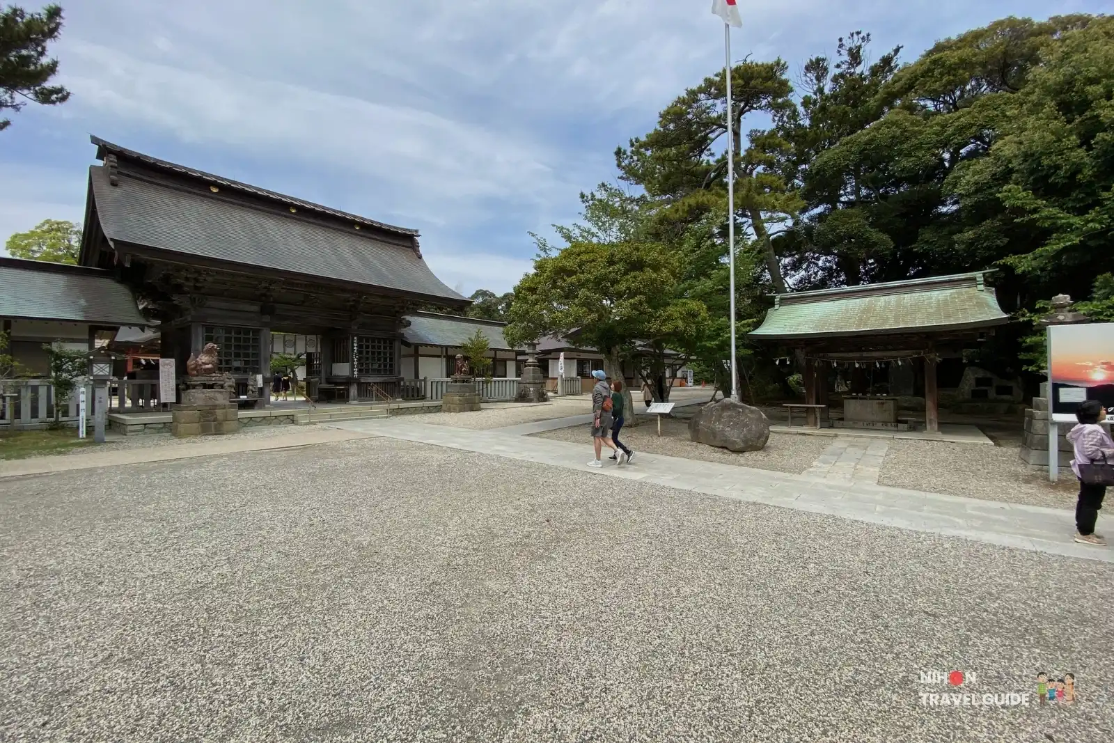 Peaceful gravel courtyard surrounded by trees and traditional buildings at Oarai Isosaki Shrine