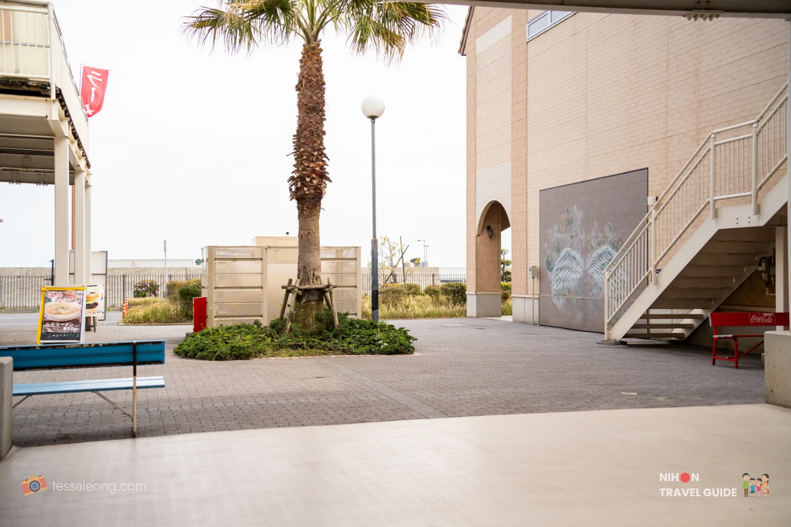 Palm tree and outdoor seating area with mural at Oarai Seaside Station Japan