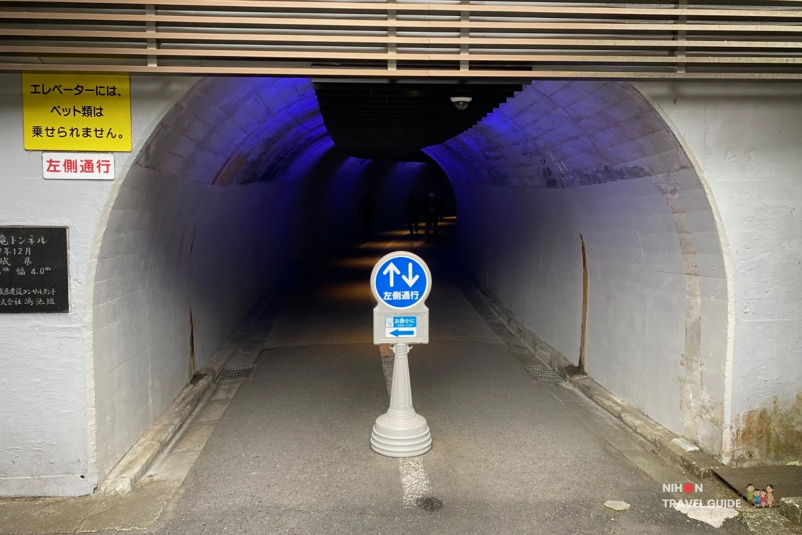Entrance to the observation tunnel at Fukuroda Falls, with keep-left signs and blue interior lighting