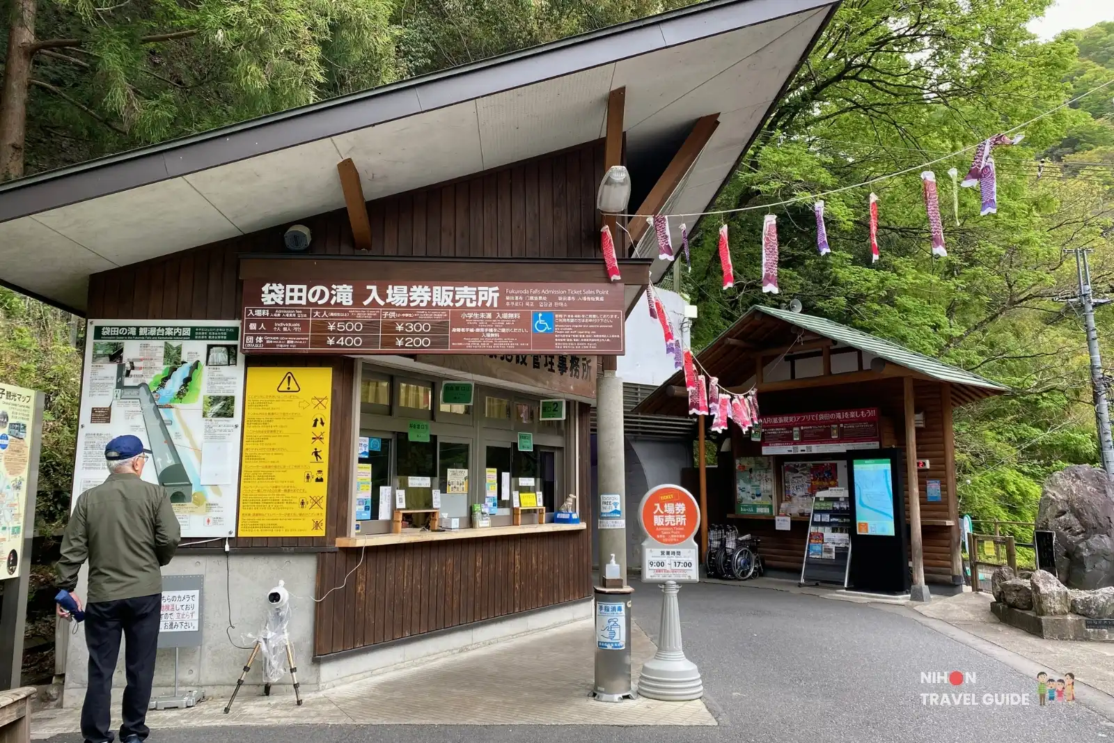 Ticket office at Fukuroda Falls showing admission prices (adult 500 yen, child 300 yen) and information boards.