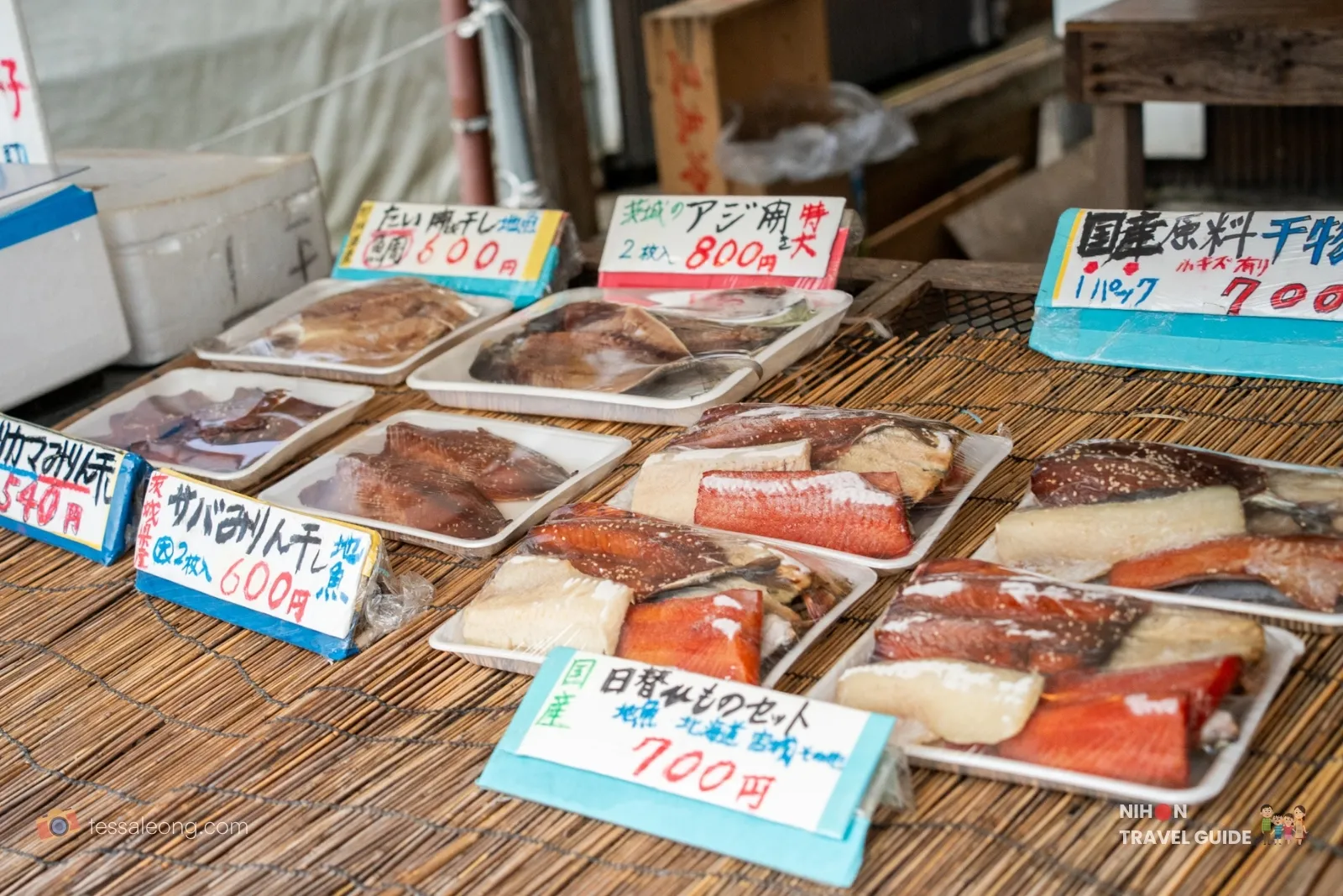 Close-up of dried fish (himono) including aji and saba on bamboo trays with price tags at a stall in Nakaminato Fish Market, Ibaraki